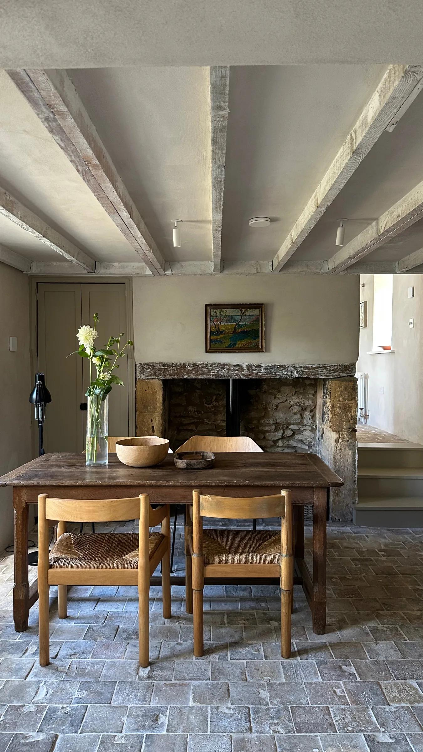 Dining room with stone floor, exposed beams and fireplace