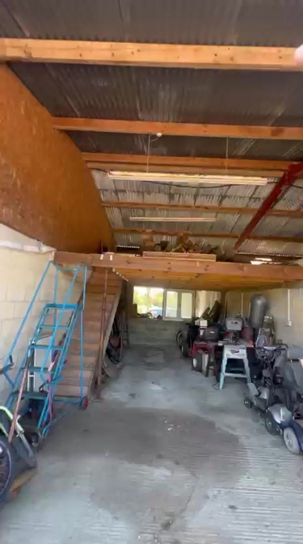 Current barn interior showing the mezzanine floor and kitchen area, before renovation — from the walkthrough video (temporary — swap for polished photography later)