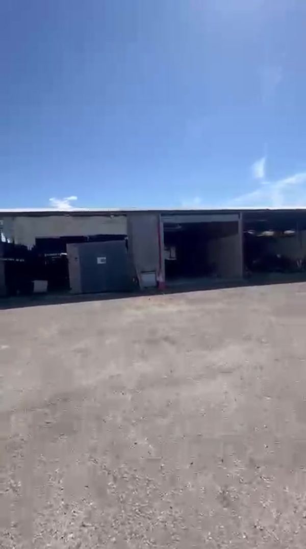 A row of storage bays on hardstanding, from the walkthrough video (temporary — swap for polished photography later)