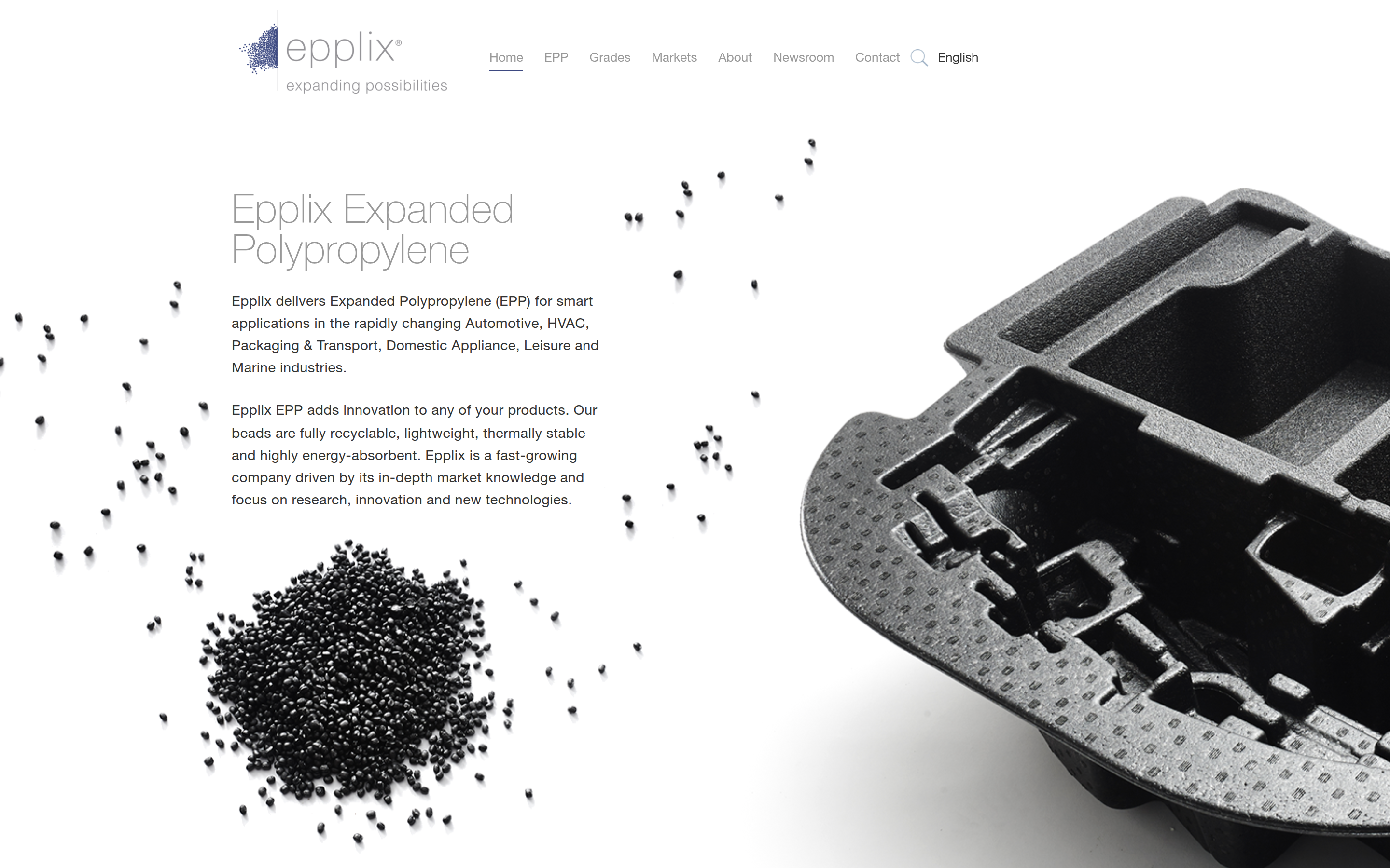 The Epplix home page in 2017: a grey wordmark top left, a menu of Home, EPP, Grades, Markets, About, Newsroom and Contact, a heading Epplix Expanded Polypropylene with two paragraphs, a heap of black foam beads scattered across the page, and a large black moulded foam part on the right.