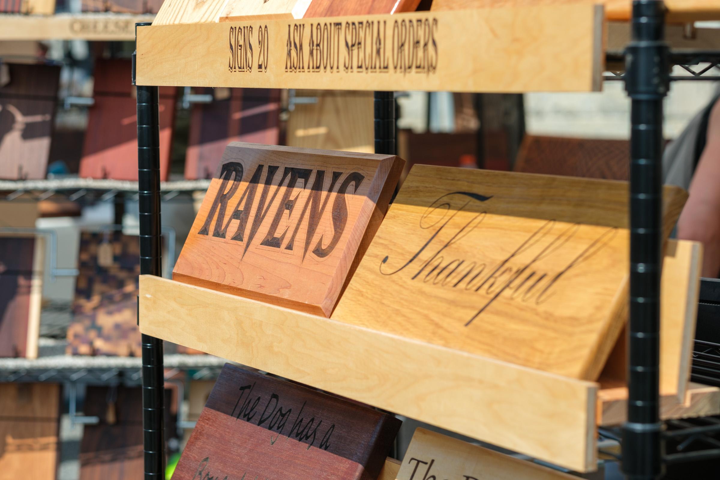 Wood-burned signs on a wire rack.