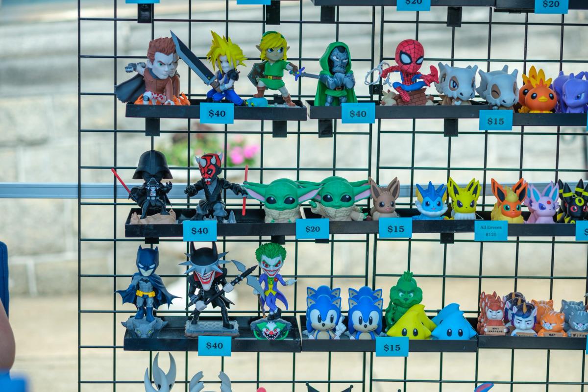Wall of vinyl figures on a wire grid with price tags.