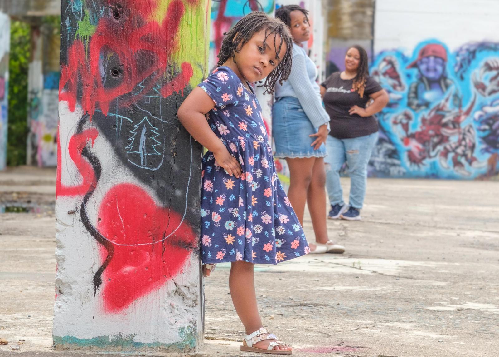 Charlie leaning against a graffiti-covered column at The Ruins in Glen Rock, PA, a red heart sprayed beside her, Cori and her mother further back in the structure.