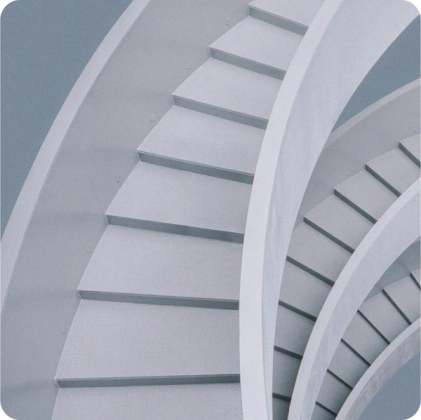Close-up view of modern, curved, white staircases with a minimalist architectural design.