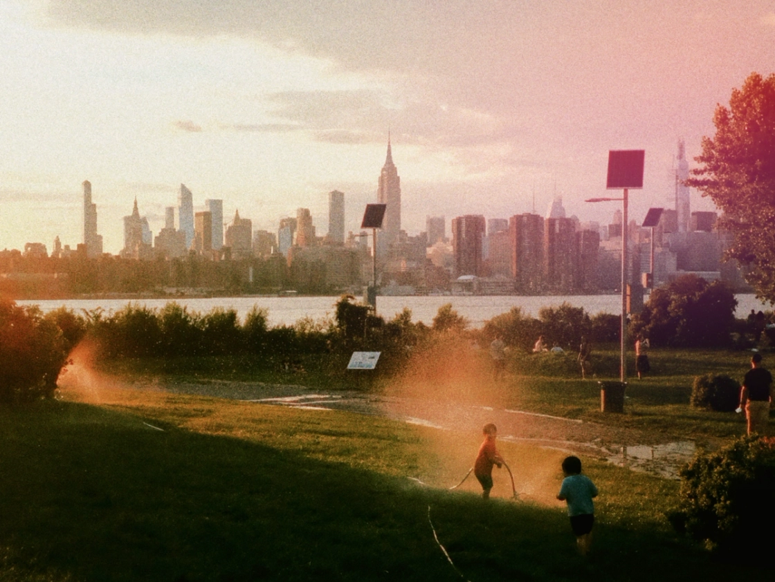 A lively scene of individuals playing in a park, framed by the urban skyline of a city in the distance.