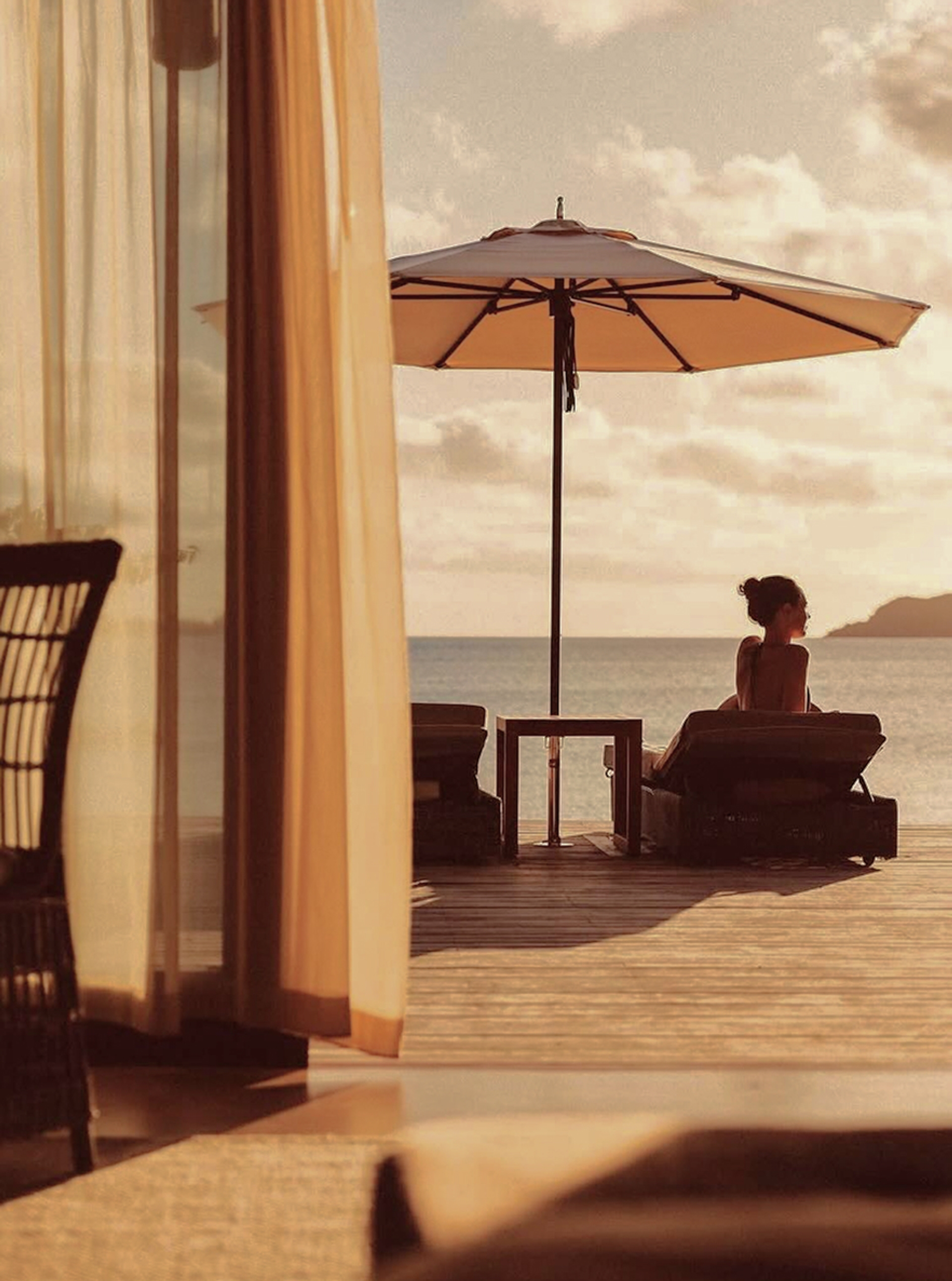 A traveller rests on a shaded oceanfront terrace