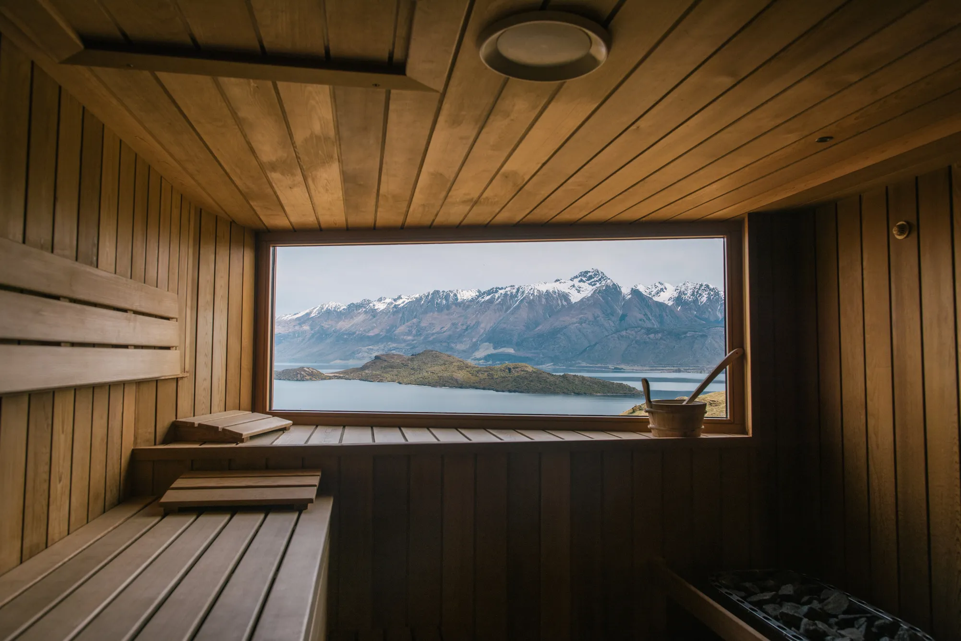 A freestanding bath beside a window overlooking an alpine lake