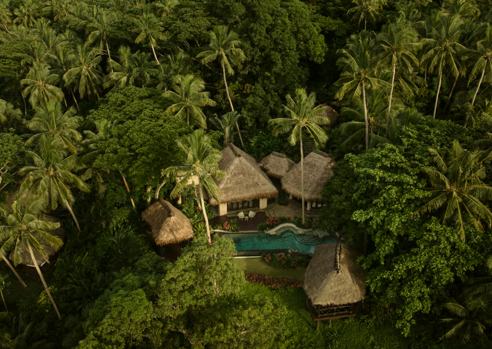 A secluded thatched villa and pool surrounded by tropical forest