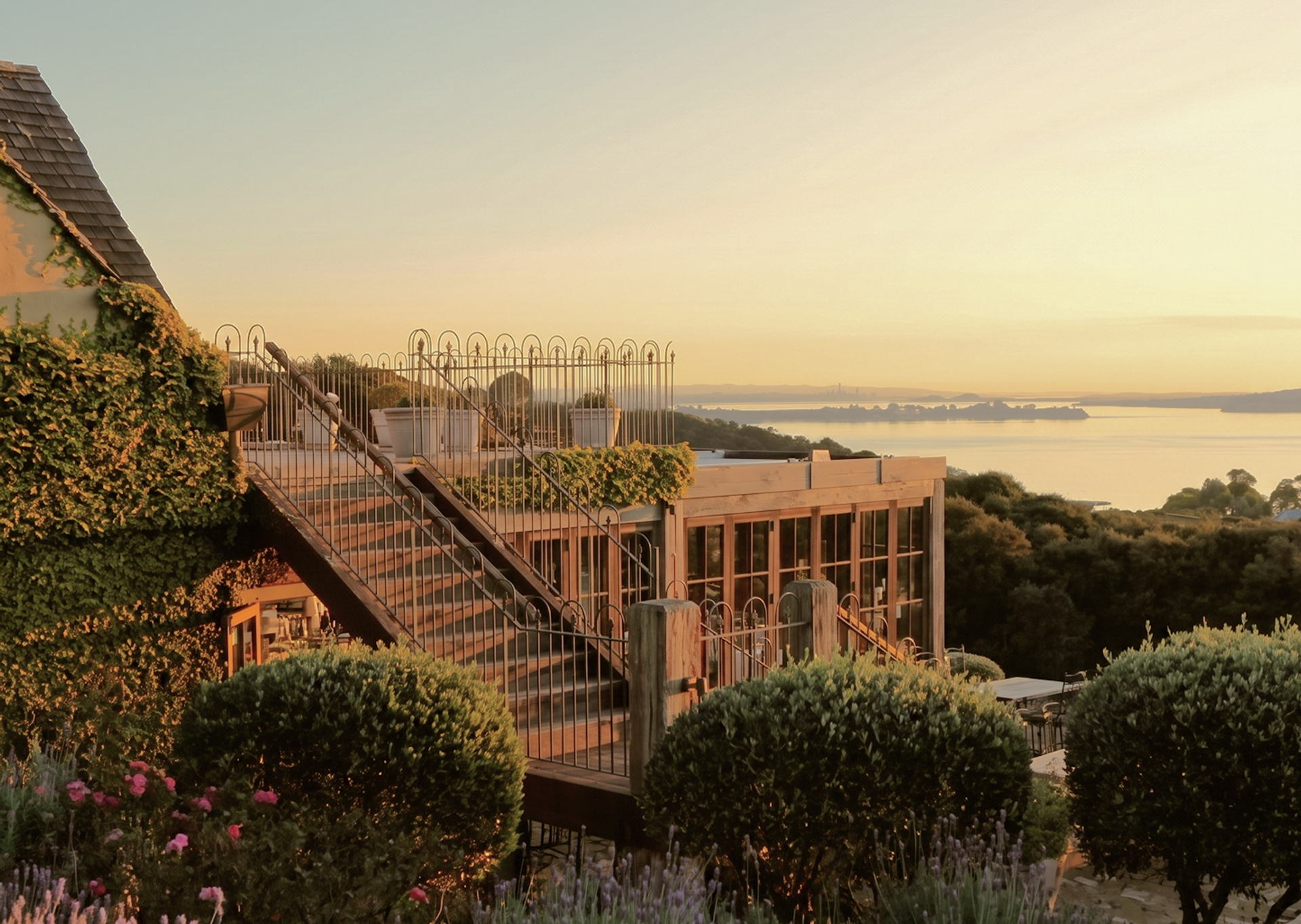 A terraced restaurant overlooks the water at sunset at Mudbrick, Waiheke.