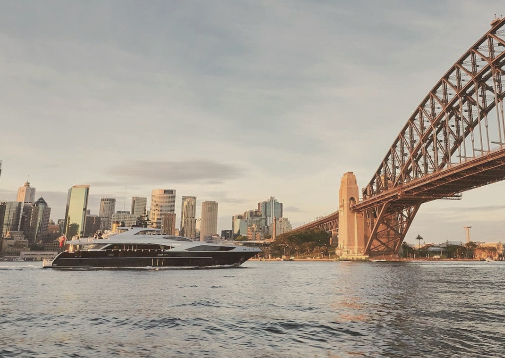 A private yacht passes beneath Sydney Harbour Bridge