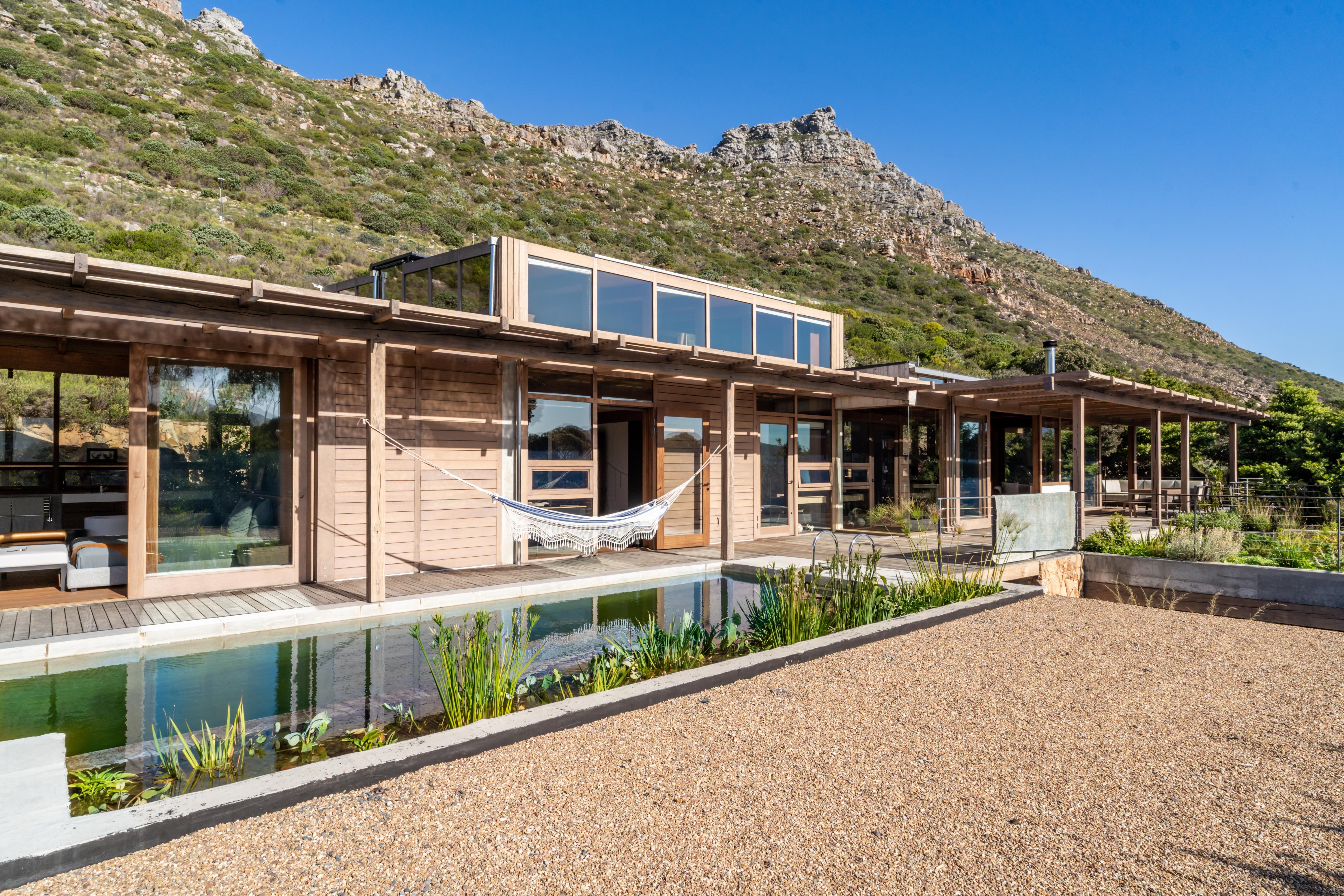 Exterior with mountain ridge behind, lap pool reflecting fynbos in the foreground