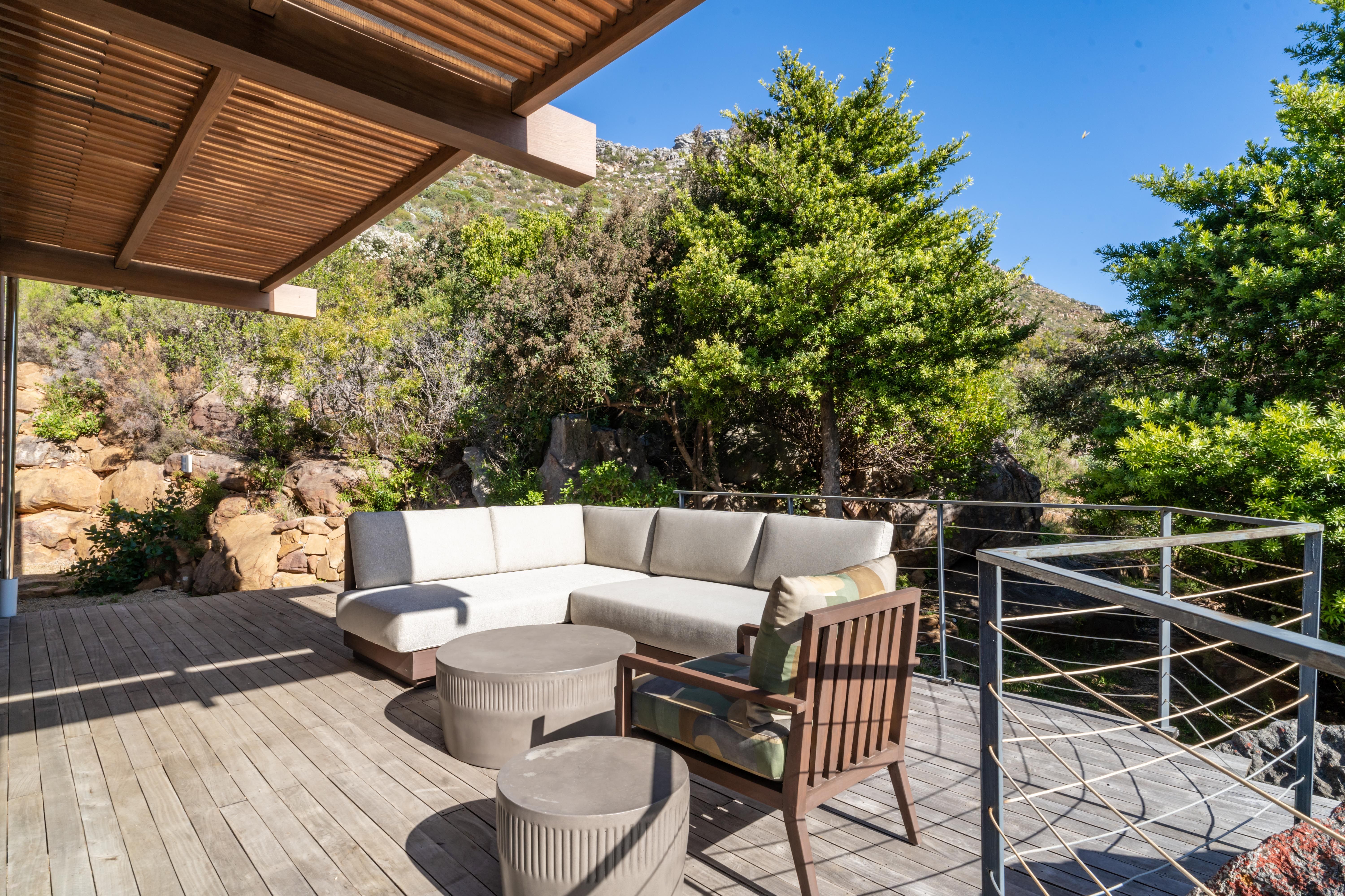 Deck nook with sectional sofa, framed by fynbos