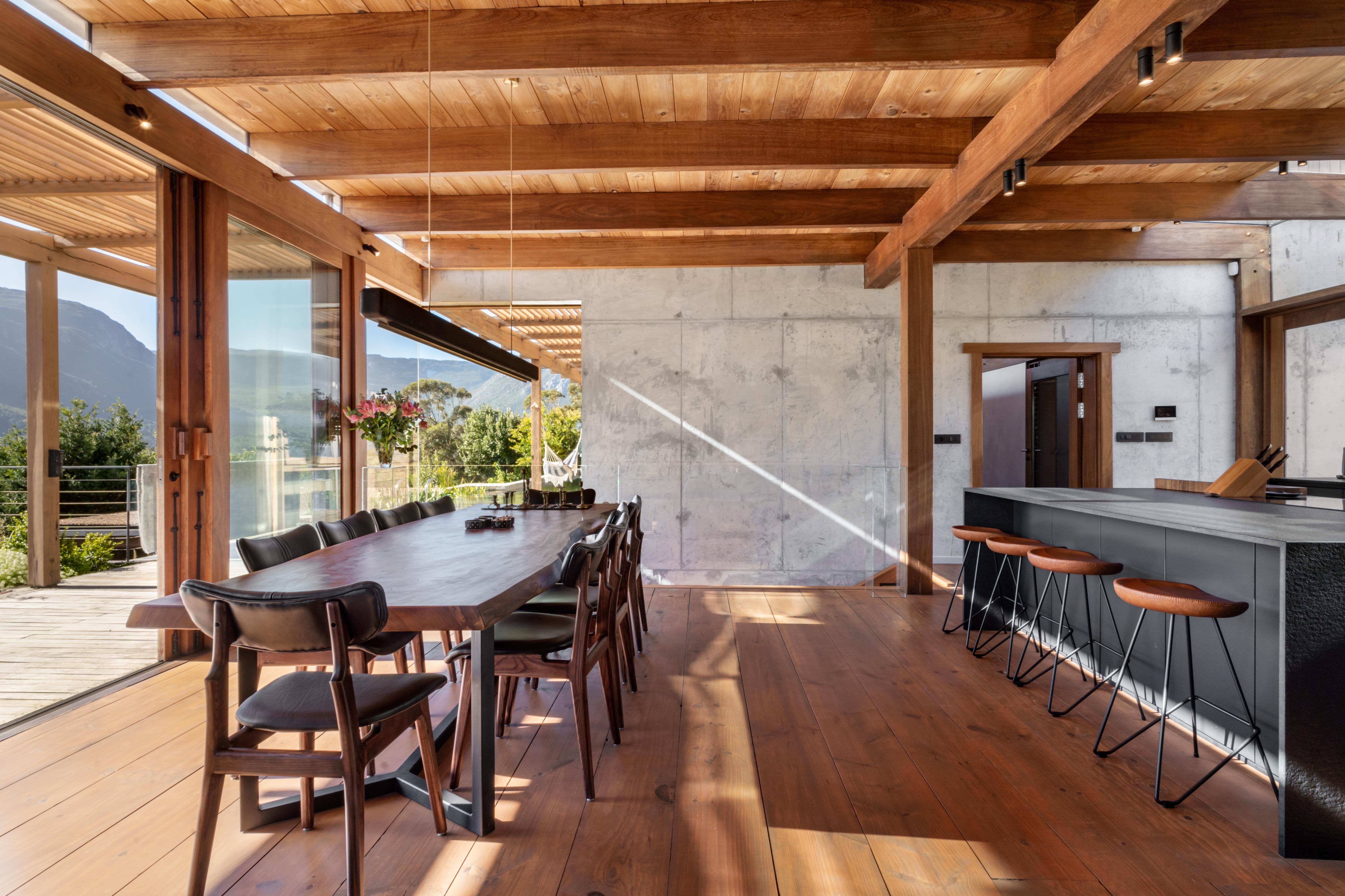 Dining table for eight with bar stools, concrete + mountain through the glass