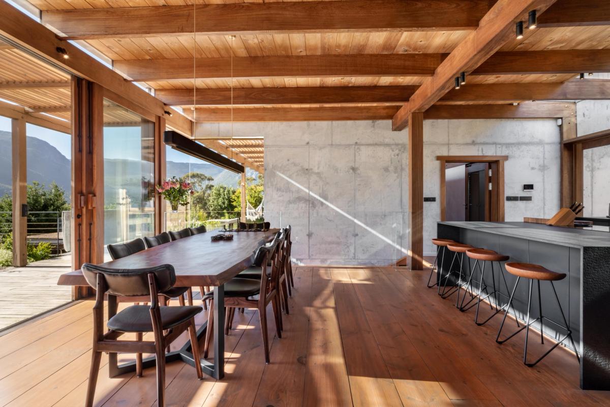 Dining table for eight with bar stools, concrete + mountain through the glass