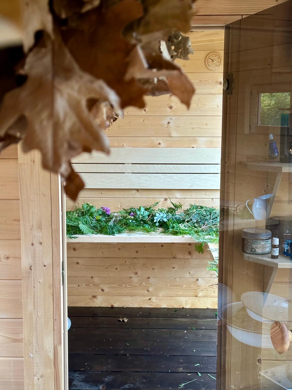 Detail of the sauna bench with herbs, leaves and flowers laid out for a session