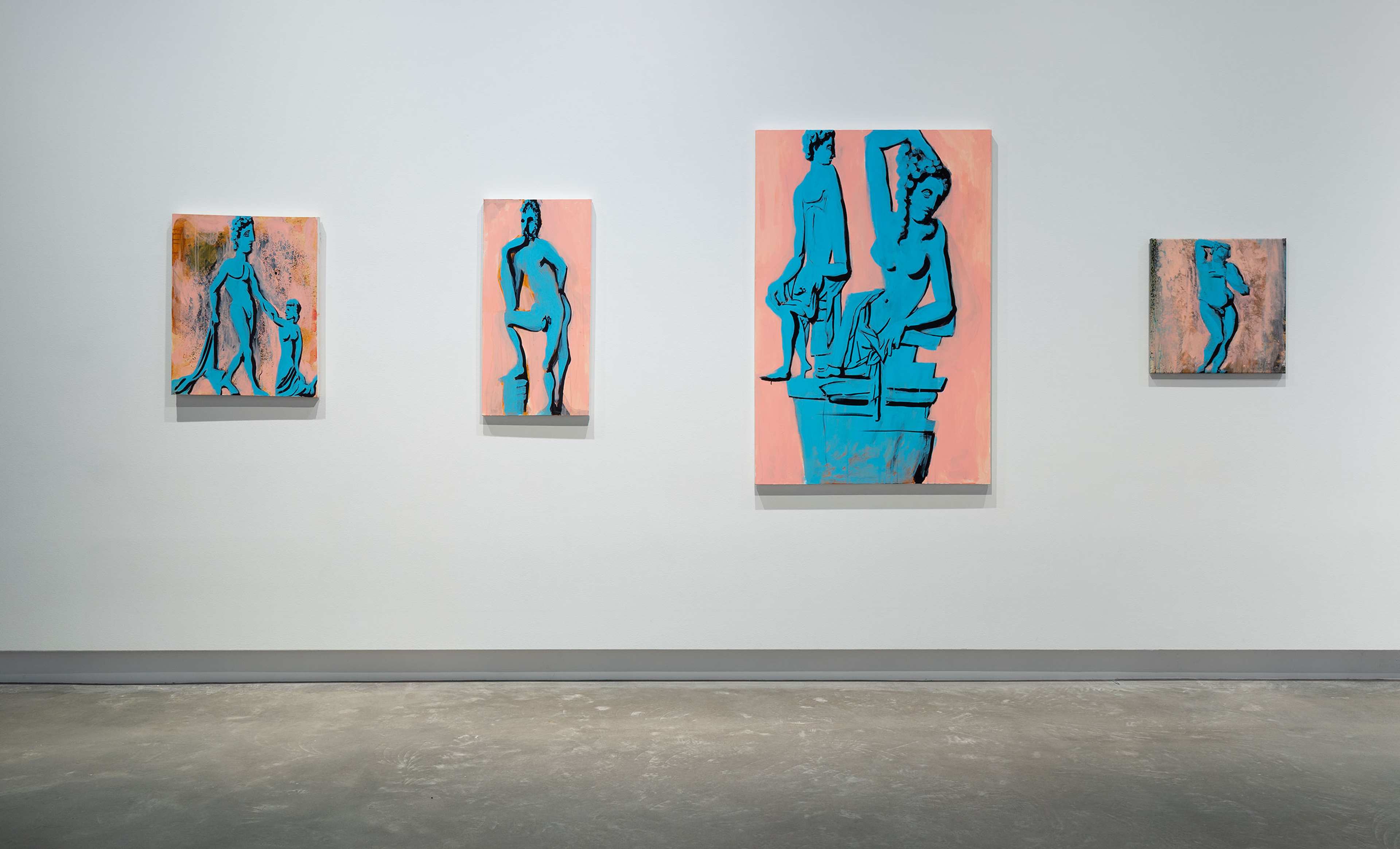 Four paintings of blue classical-style statues on pinkish backgrounds are displayed on a white gallery wall above a concrete floor. The artworks vary in size and depict different poses of standing and seated figures.