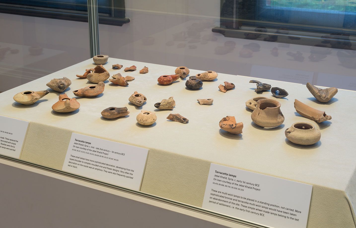 An image of a vitrine displaying small ancient ceramic vessels