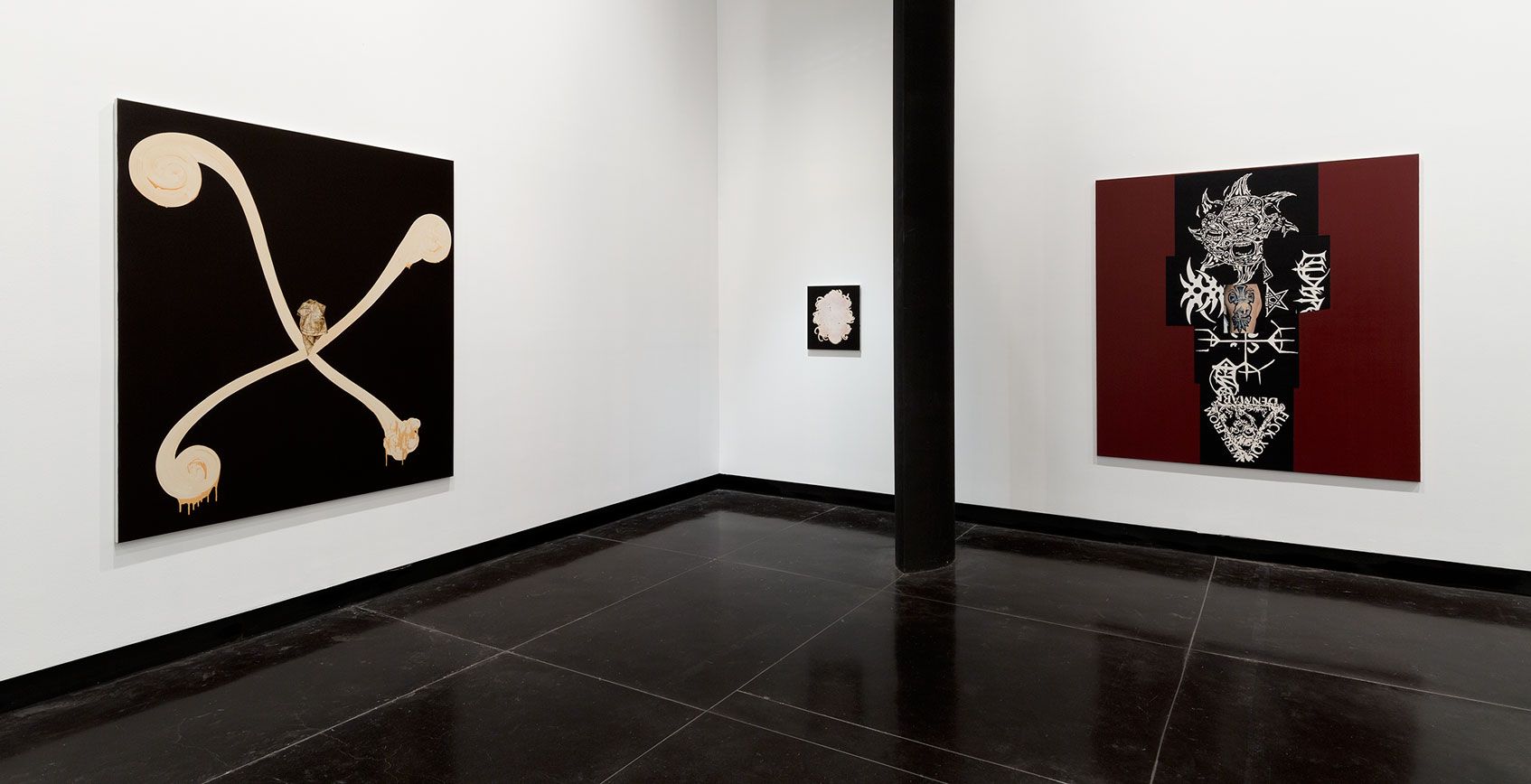 A photograph of a gallery space with two large and one small abstract painings in black, white and dark red. The painting on the left features a curly white X on black background.