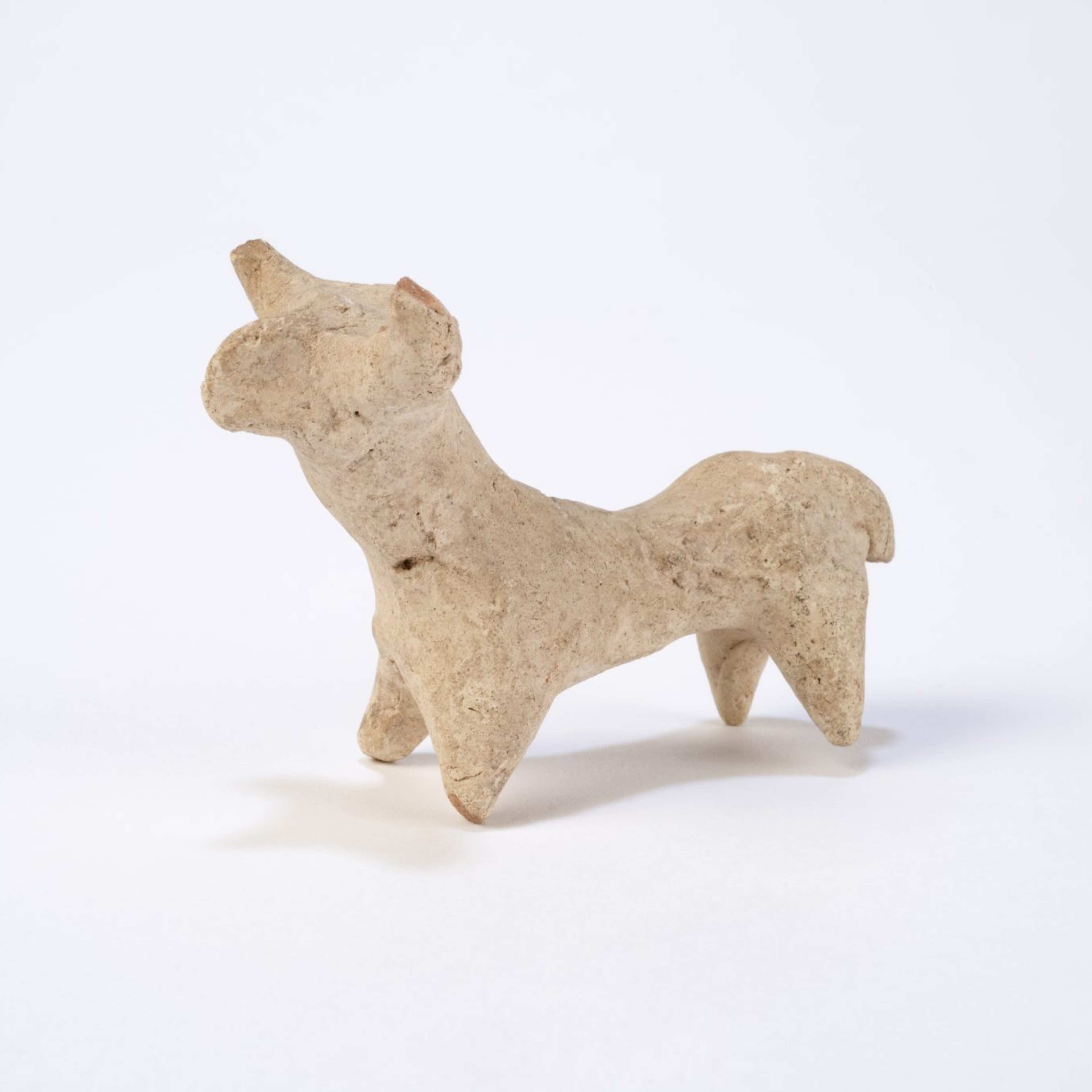 A photograph of a simplistic ancient animal figurine made of clay