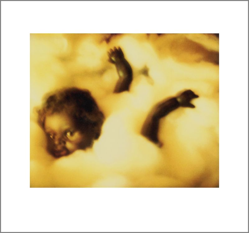 A head and body of a brown doll in a cloud