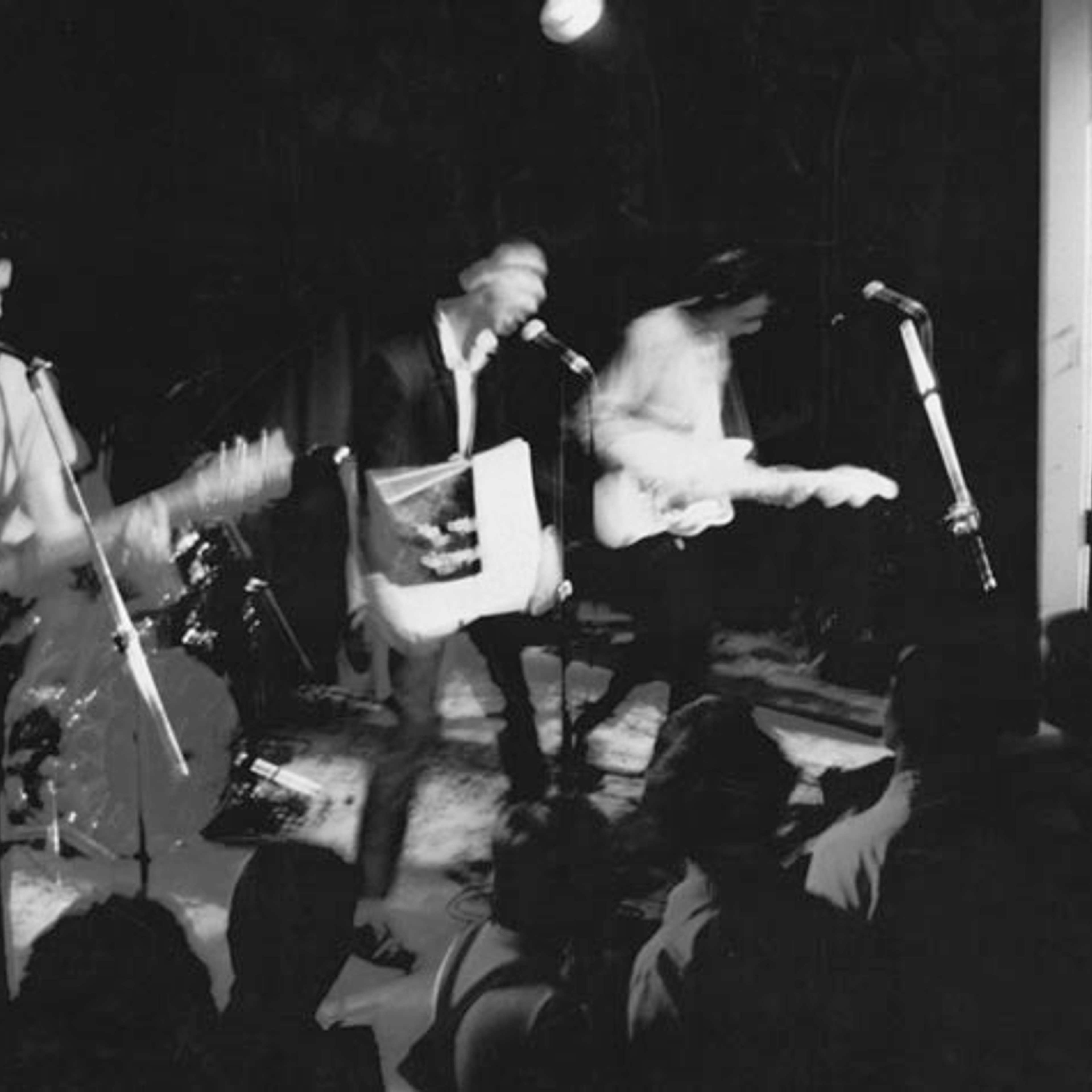 A black and white photograph of a band on stage