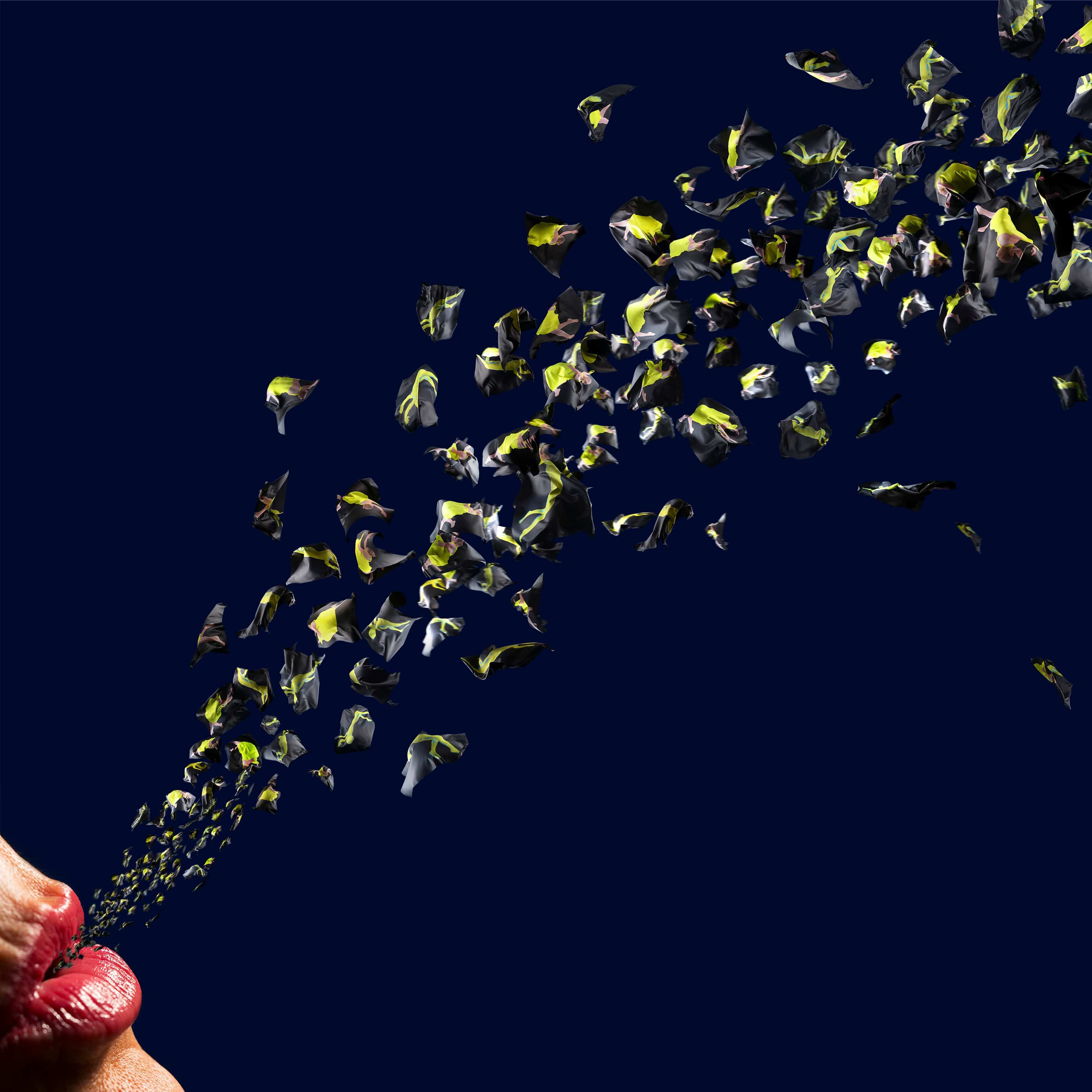 A photograph of yellow fragments flowing out of lipsticked lips forming an arch against a black background