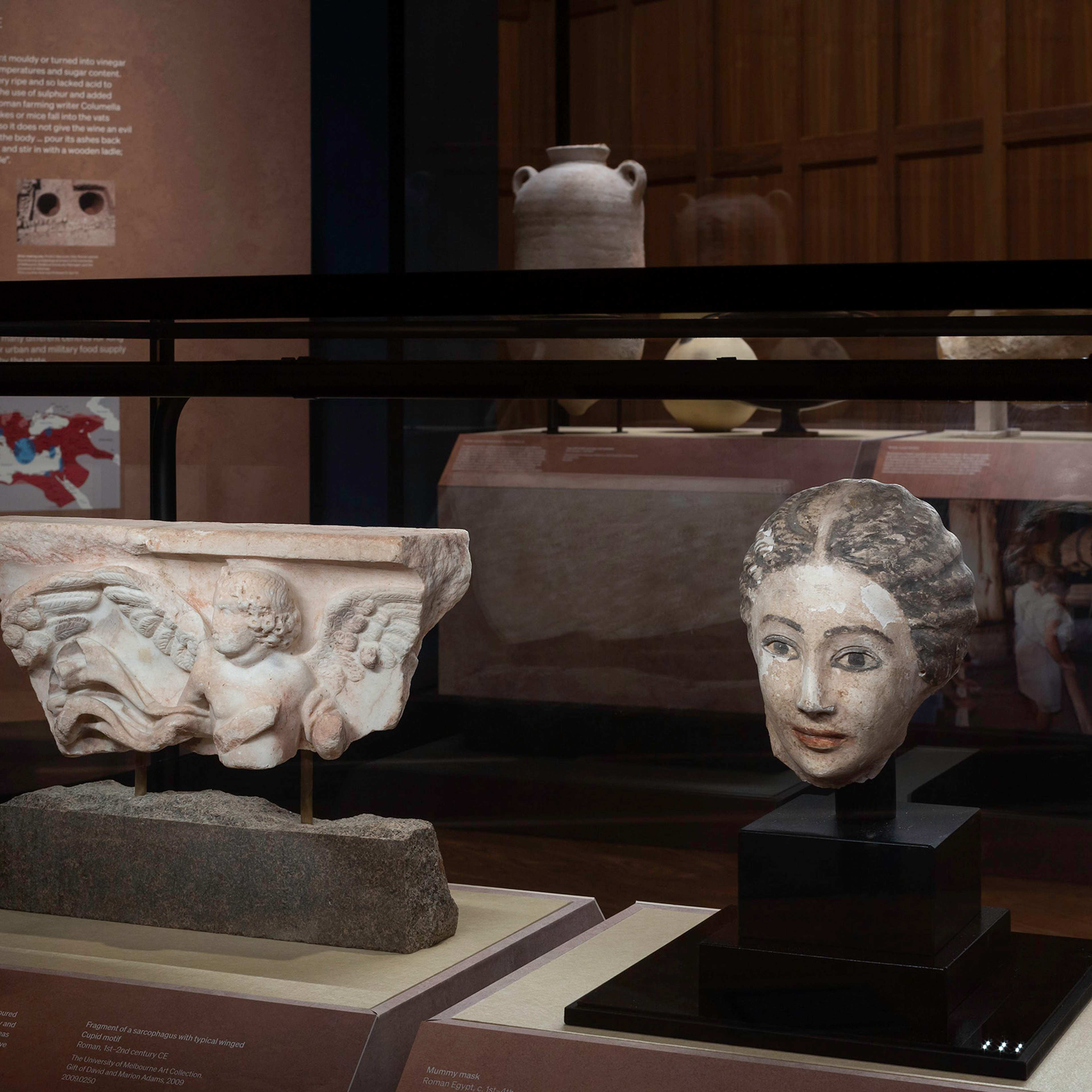 A ceramic sculpture of a head in a glass case in a gallery