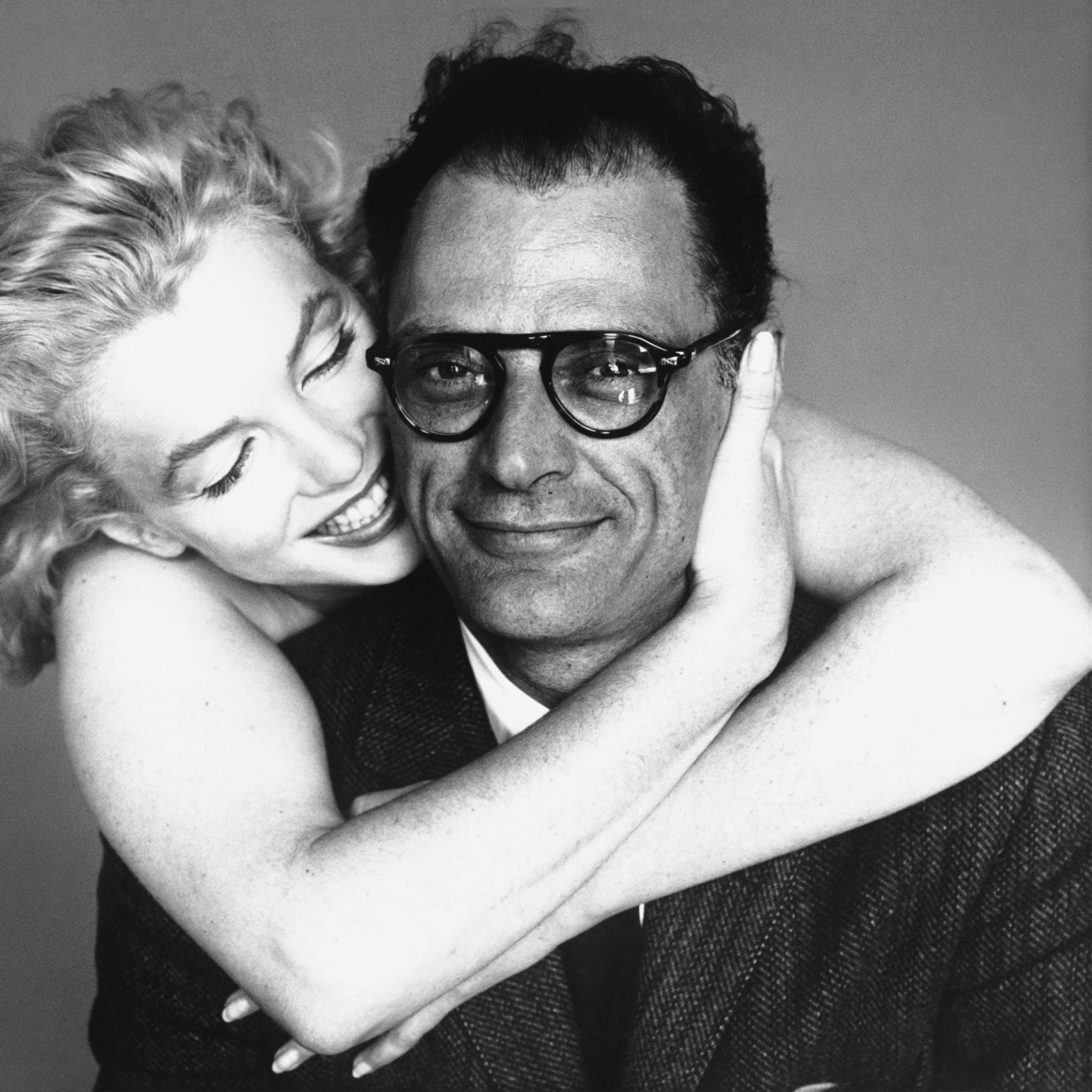 A black and white photo of Marilyn Monroe hugging Arthur Miller