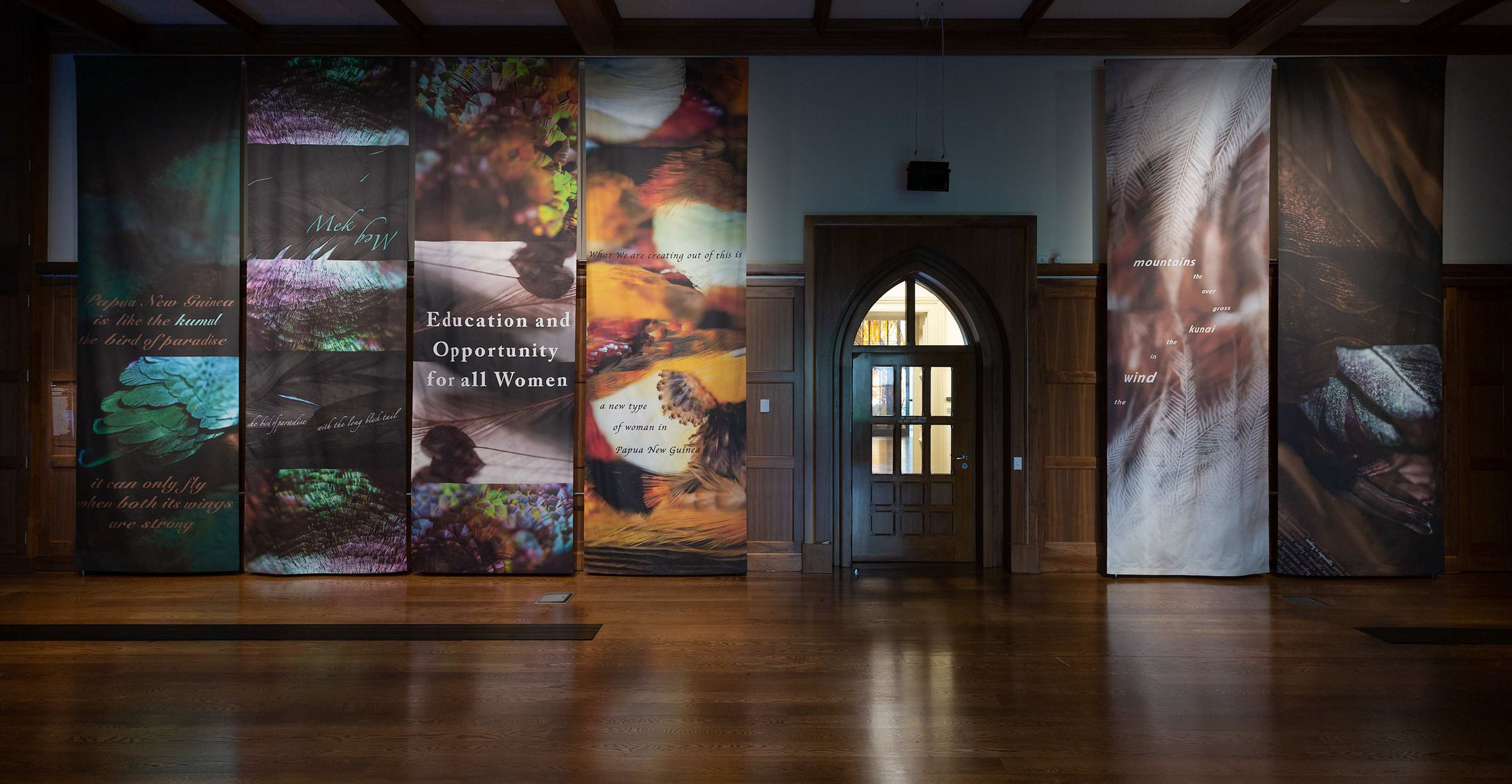 The entrance to exhibition at Old Quad gallery with floor to ceiling hanging artworks about education for women