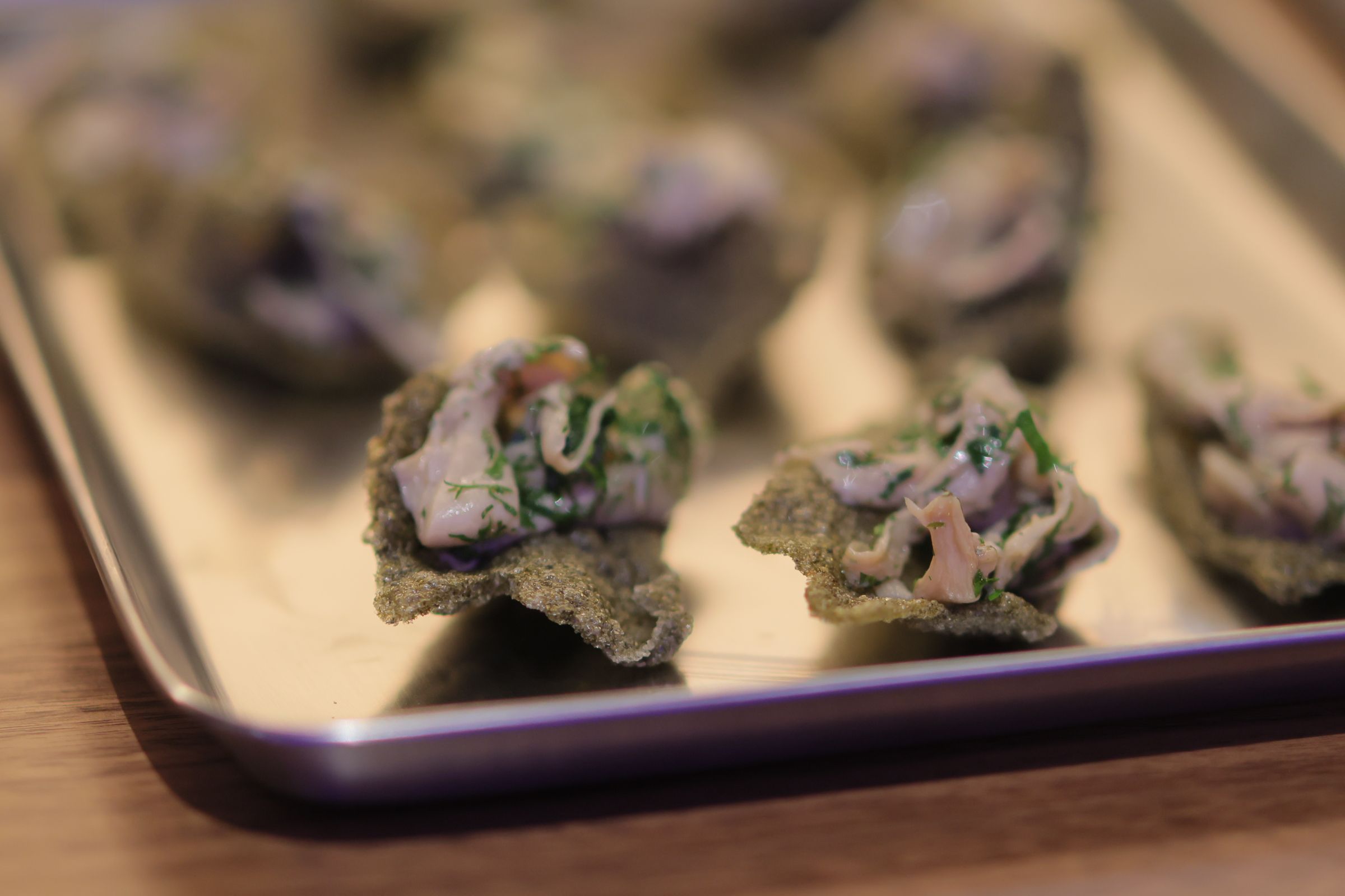 A creative photo of non descript bite sized hors d'ouvres on a silver platter