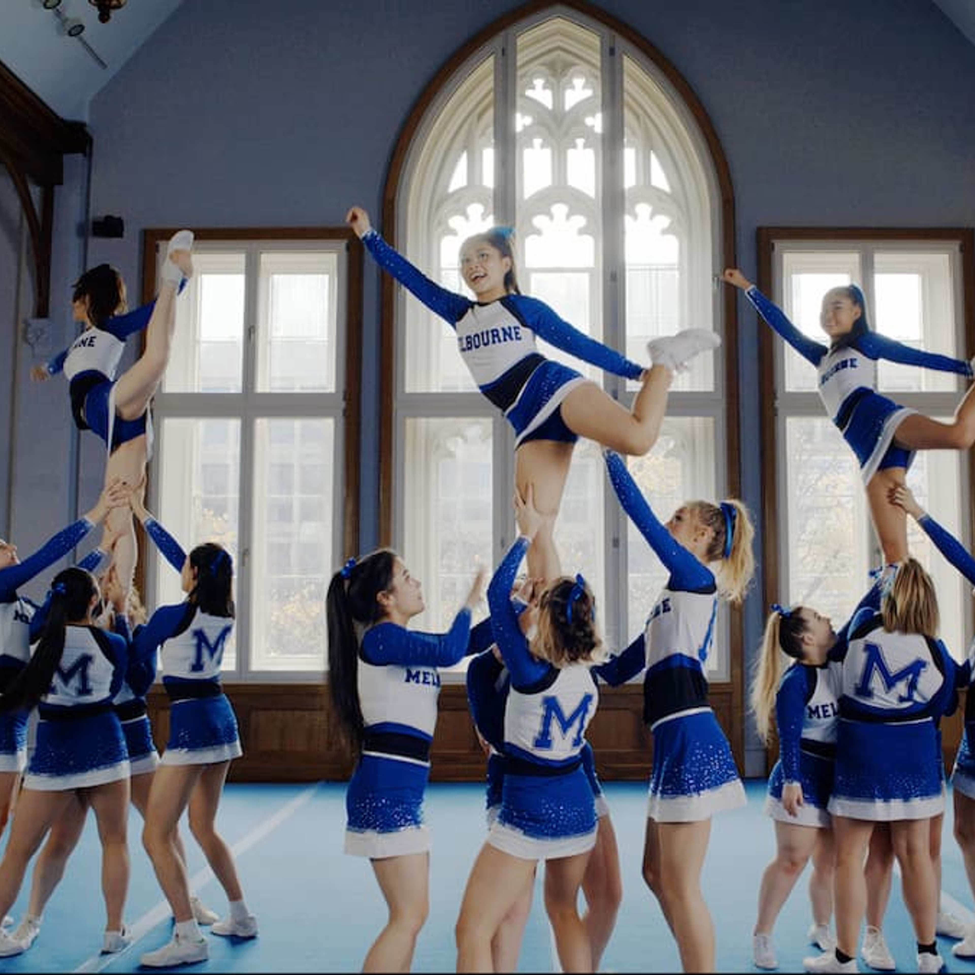 A group of cheerleaders in blue and white costumes perform