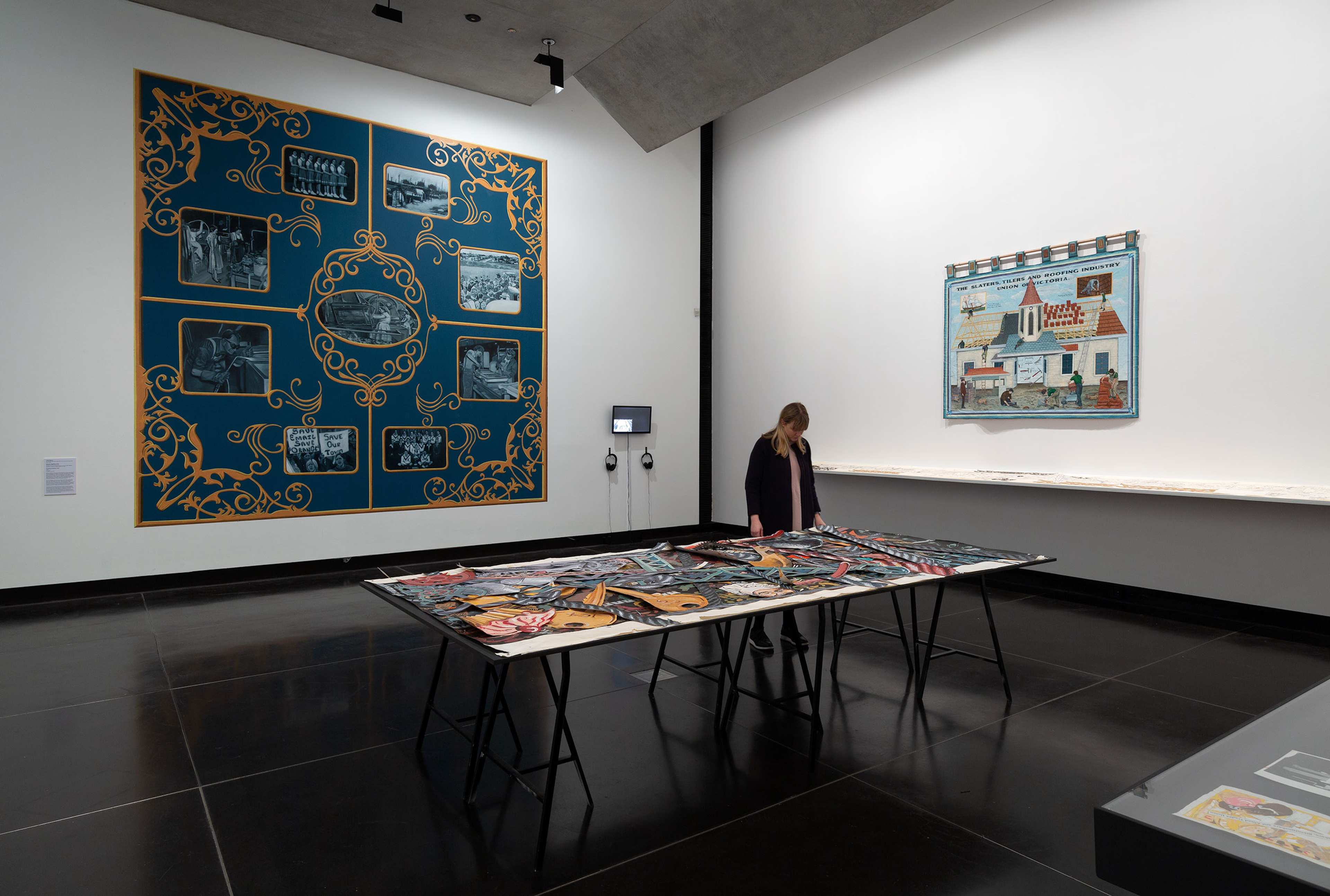 A visitor looks at art on a table in a gallery