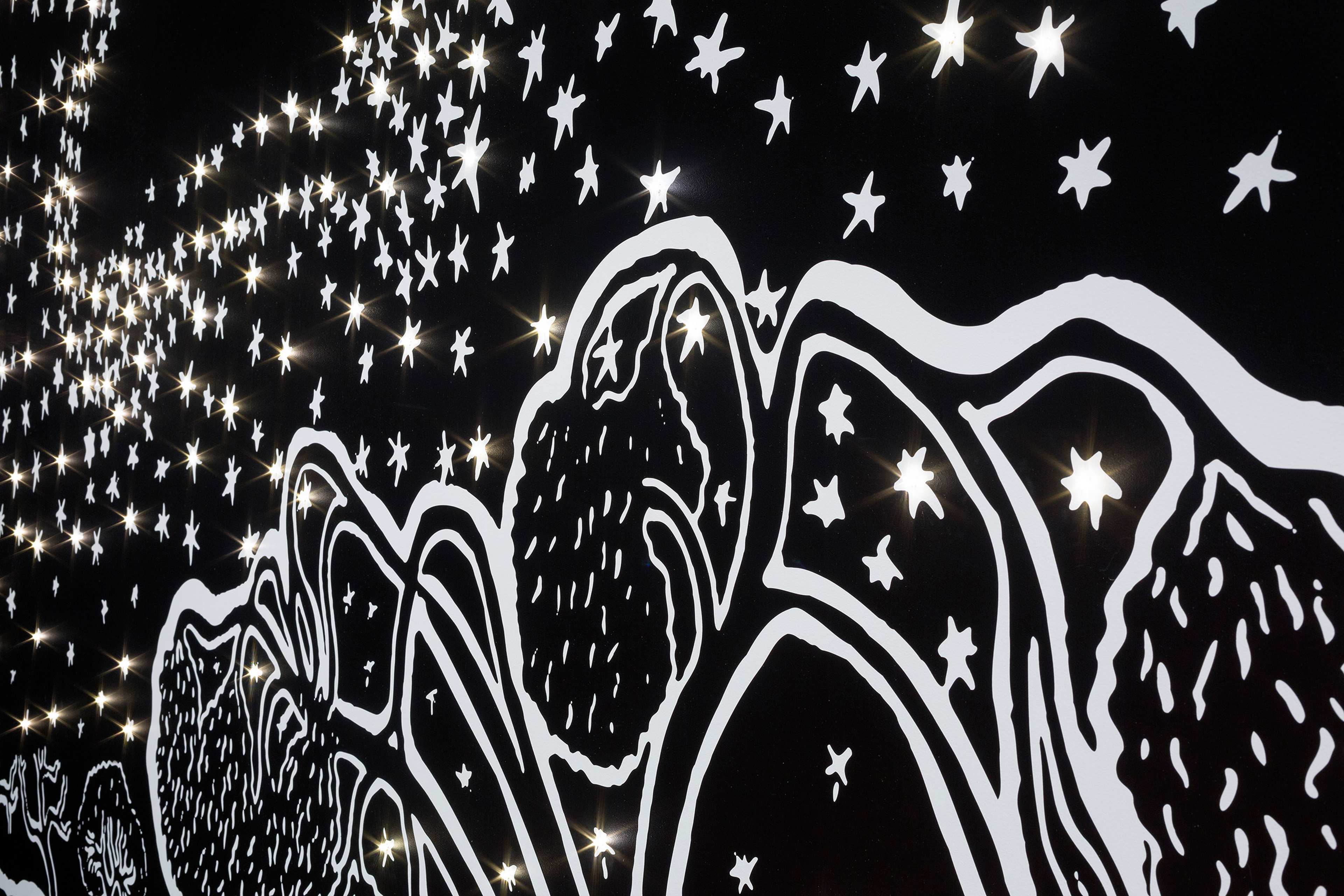 A black and white mural features abstract mountain shapes and numerous star illustrations, with real lights embedded among the stars, creating a glowing, starry night effect.