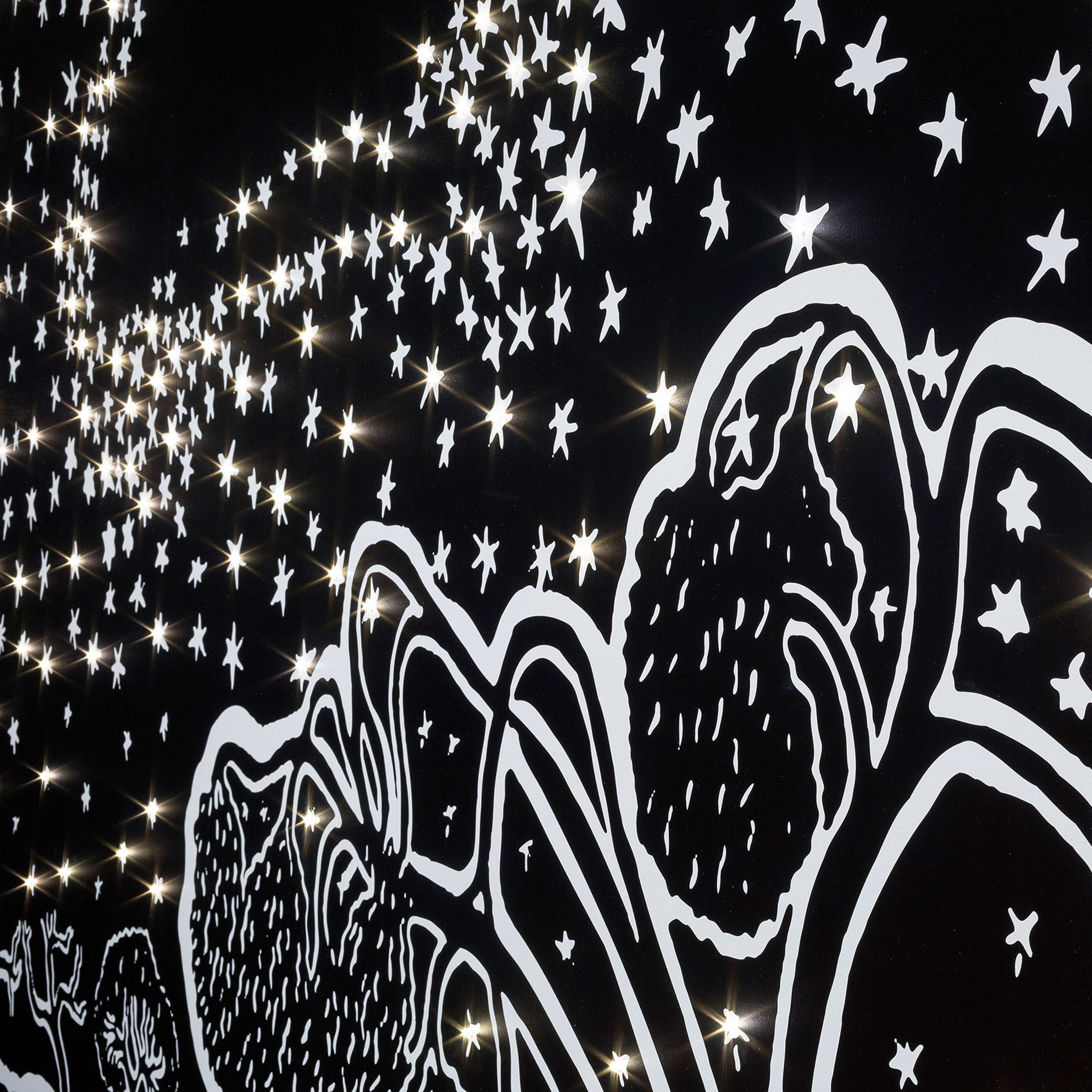 A black and white mural features abstract mountain shapes and numerous star illustrations, with real lights embedded among the stars, creating a glowing, starry night effect.
