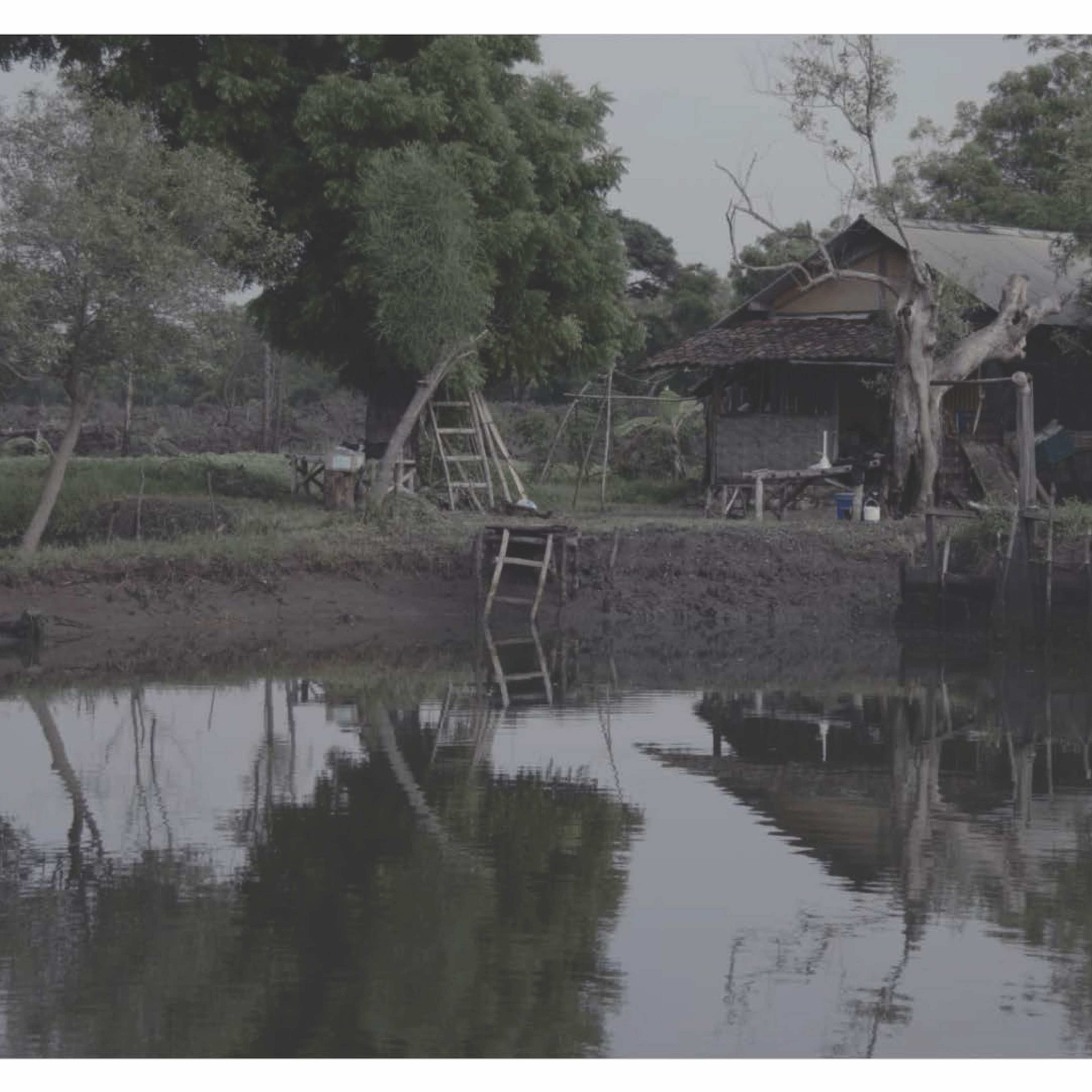 A rudimentary wooden hut at the edge of water
