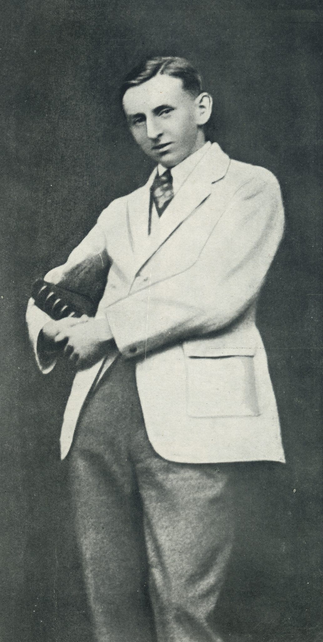 A black and white photographic portrait of a person dressed in a suit