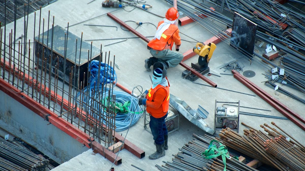 Construction excavation site with heavy machinery and safety protocols