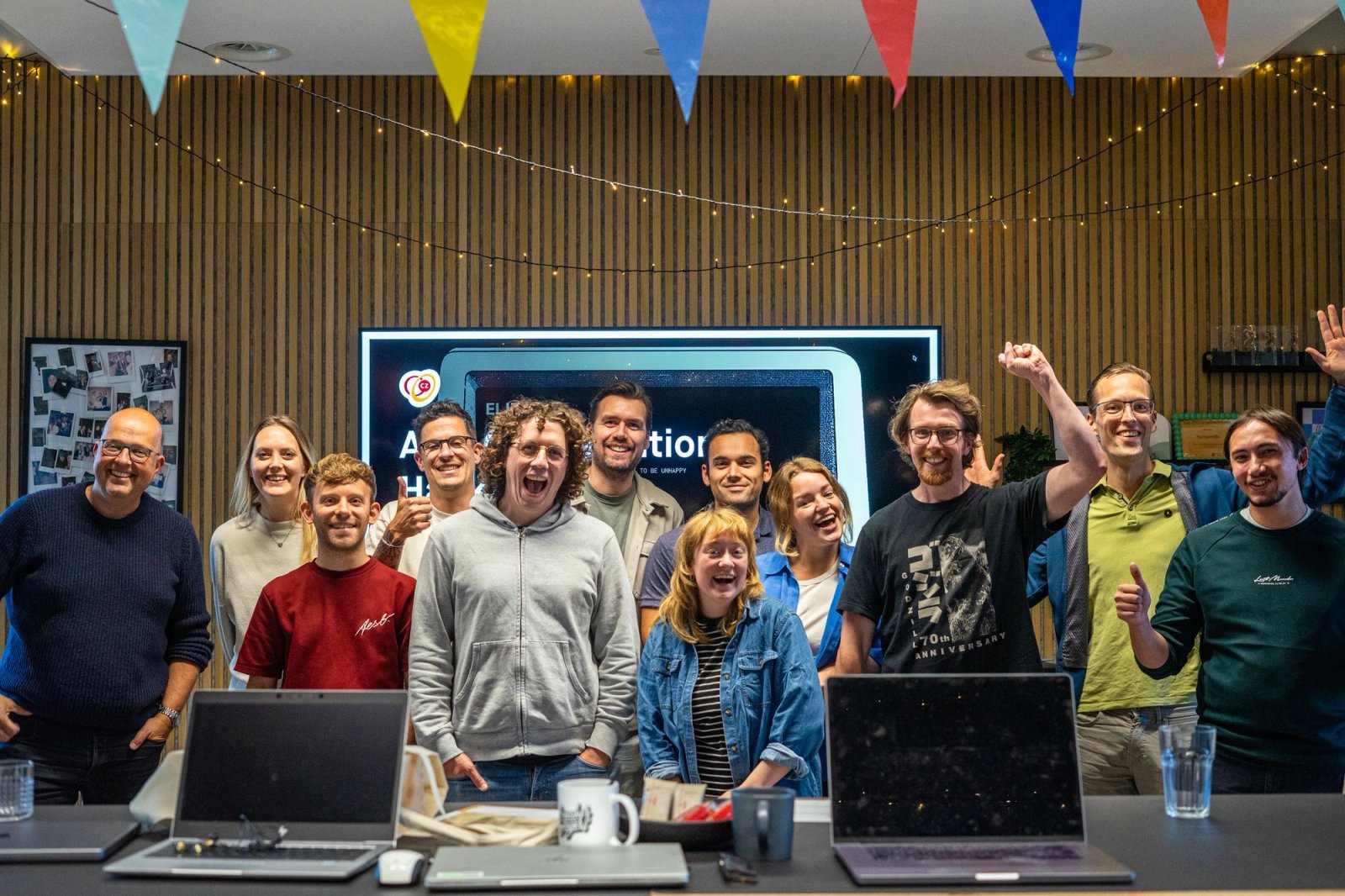 Deelnemers aan de CZ hackathon kijken naar de kick-off presentatie op een televisiescherm