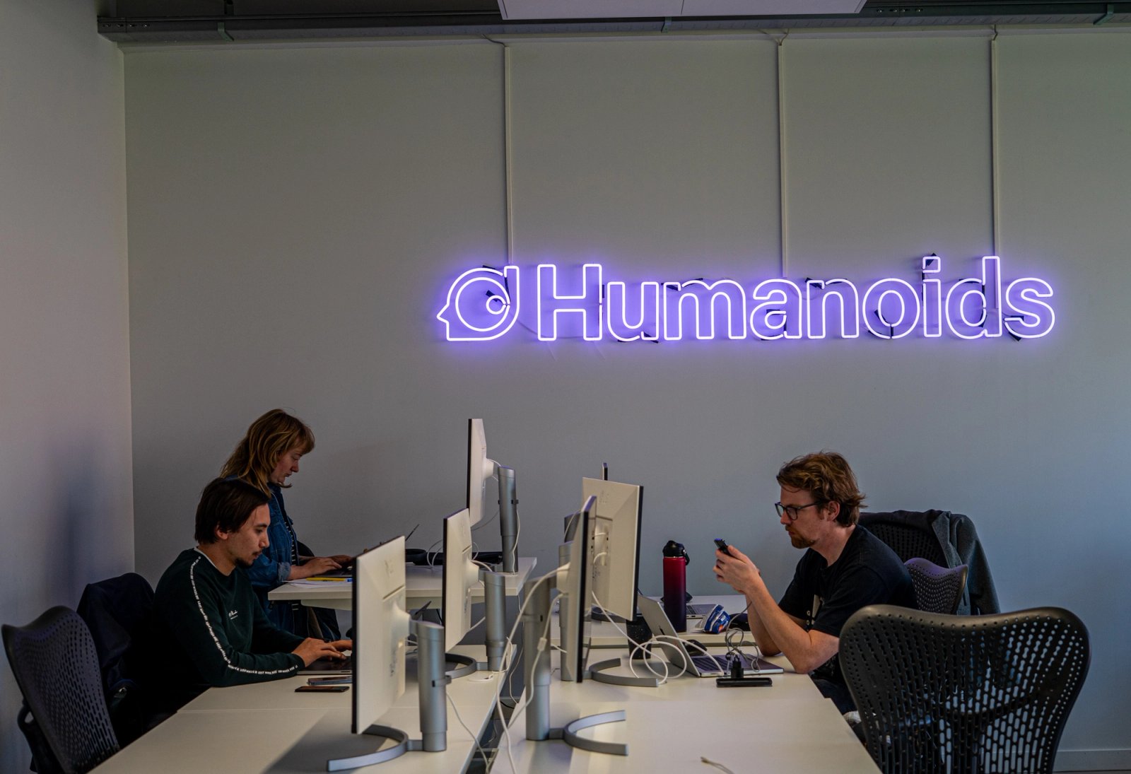 Three participants working at their desks during the AI & Conversational Hackathon at Humanoids.