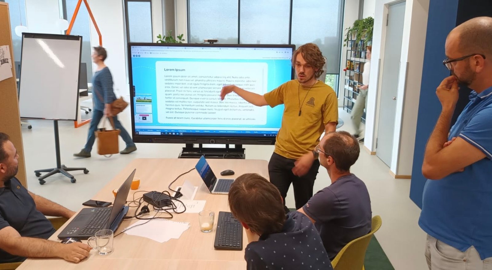 Mensen in een stakeholder feedback sessie met op de achtergrond een digibord met de Zwijsen app.