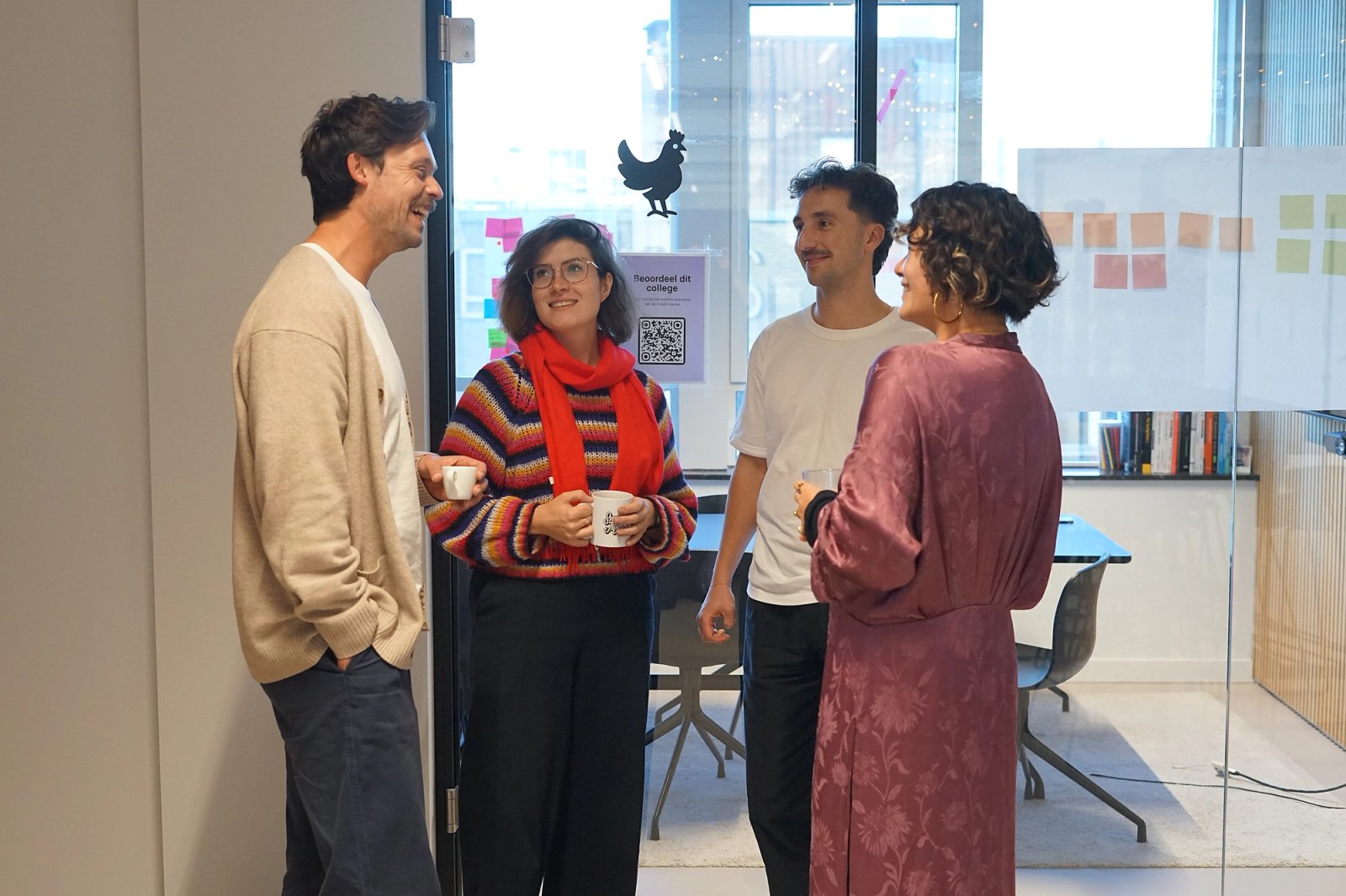 Vier Humanoids UX designers voor een vergaderruimte.