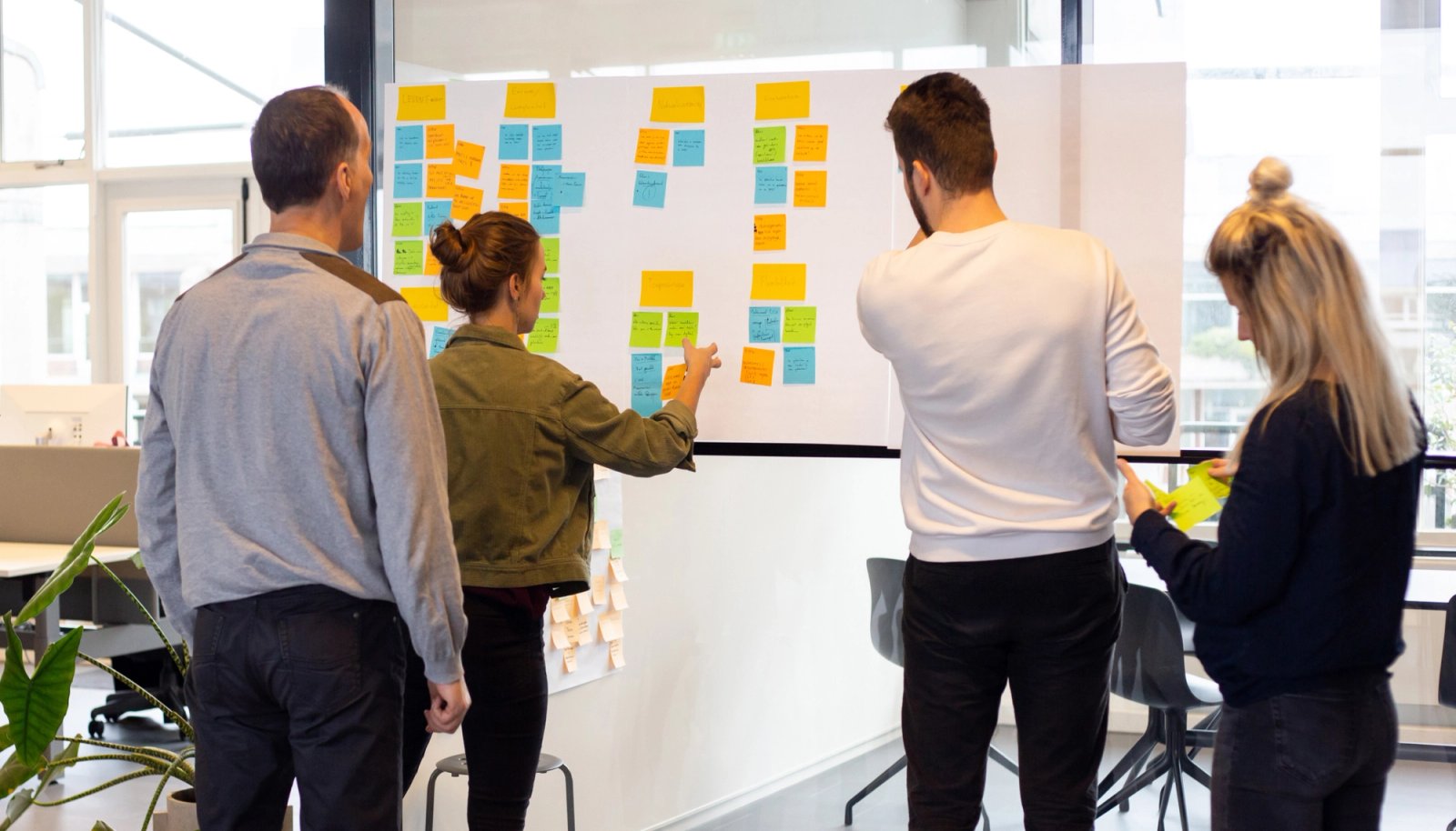 Groep mensen bij een muur met briefjes.