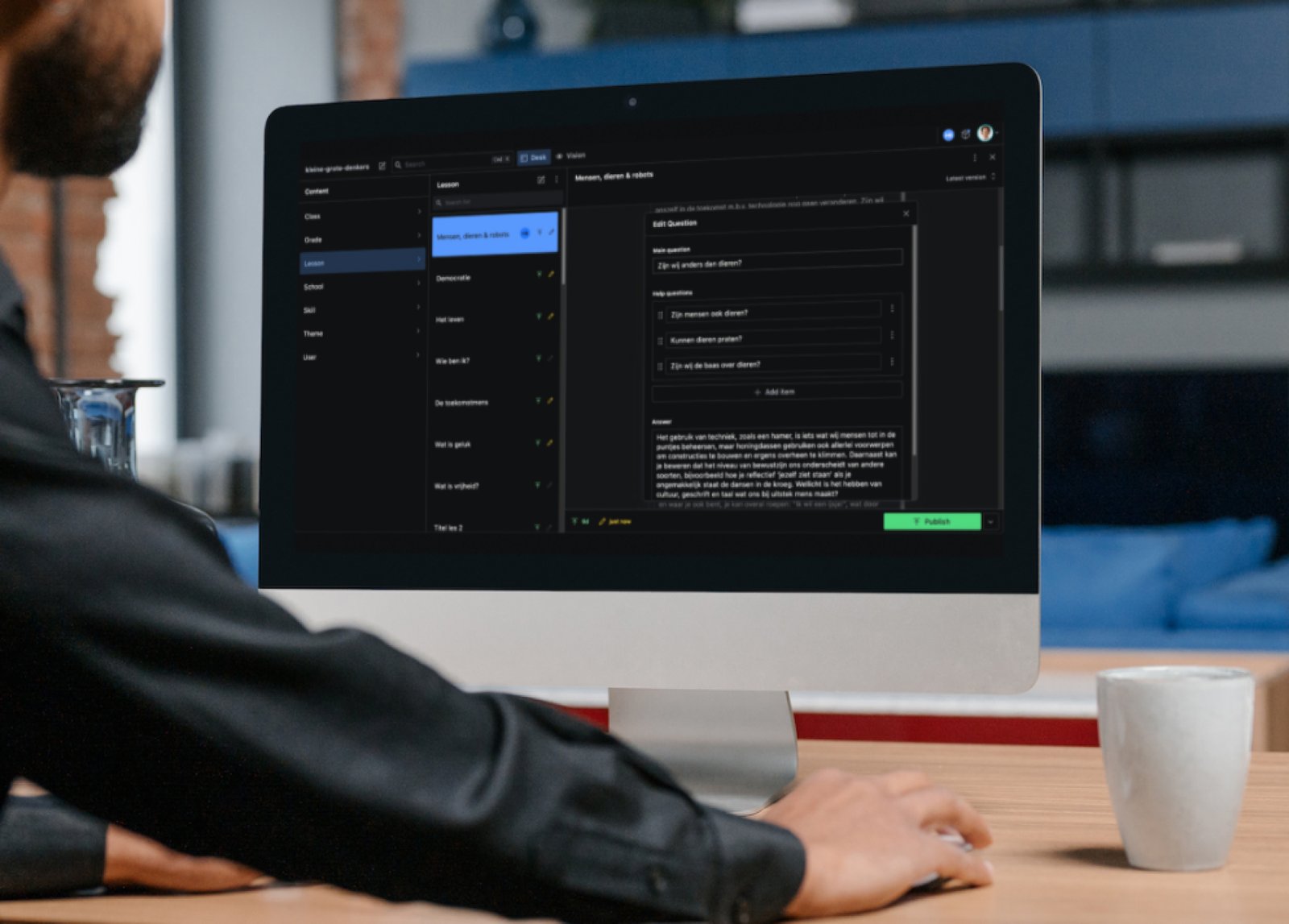 Een persoon achter een computerscherm met daarop een content management systeem