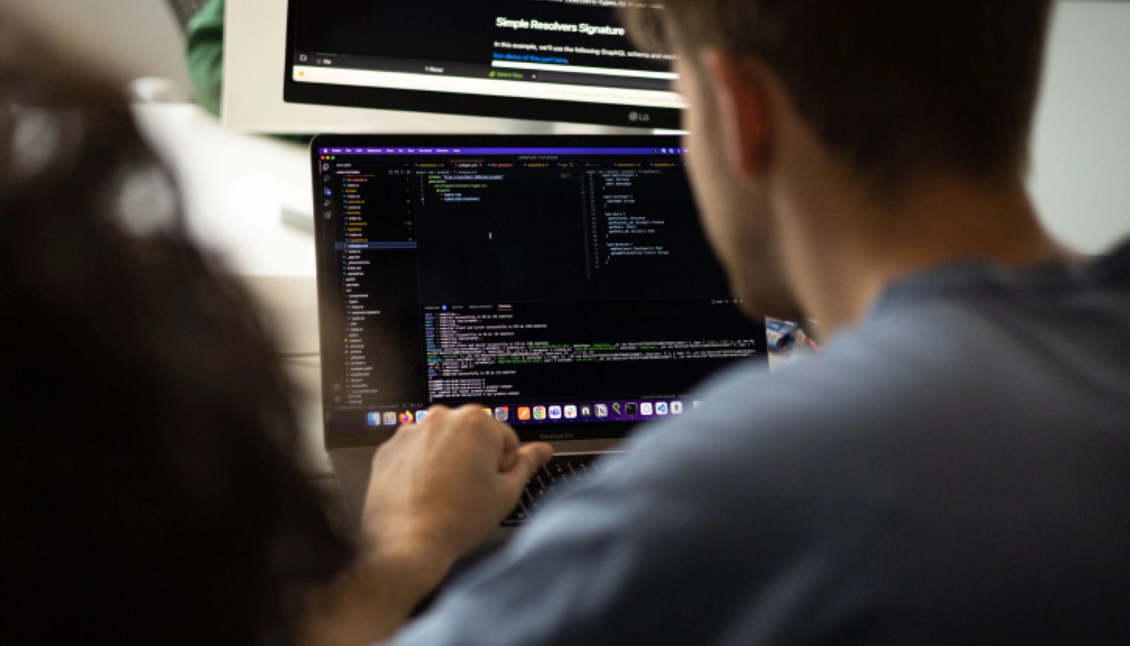 Iemand aan het programmeren achter een laptop.