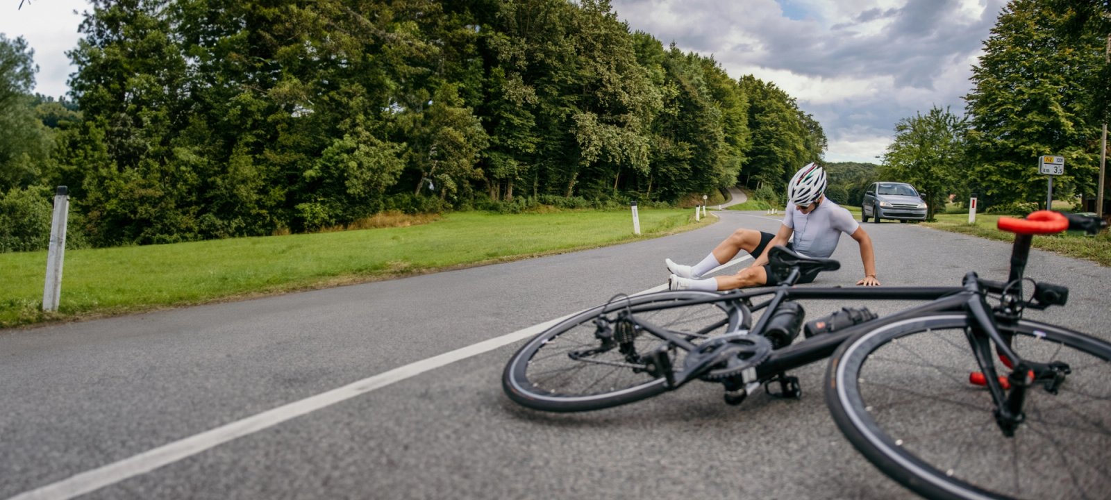 Iemand op de weg gevallen van zijn fiets.