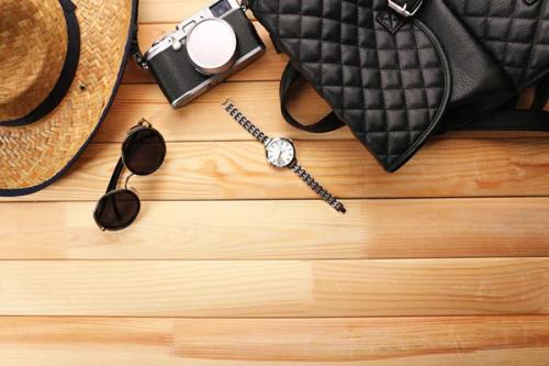 Aerial view of analog camera, watch, glasses, purse and hat on top of a table
