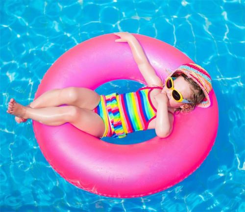Bebe acostada en un flotador tomando sol con lentes.