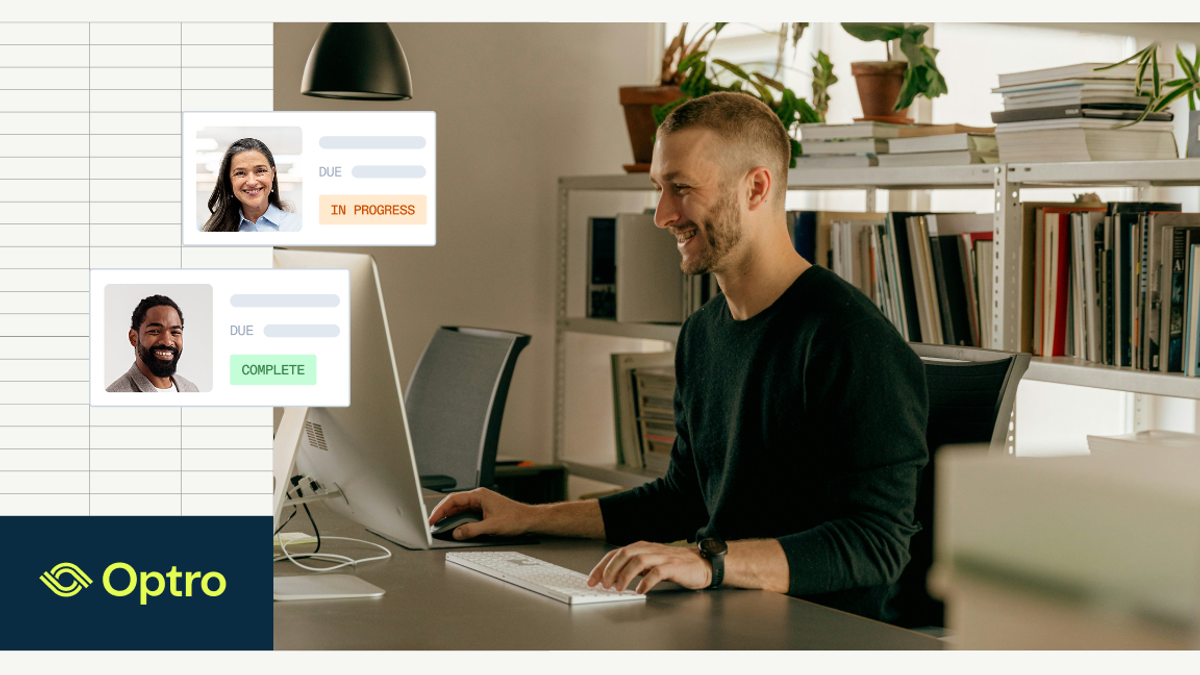 A smiling man works at a computer in a modern office, with digital overlays showing project task statuses for teammates.