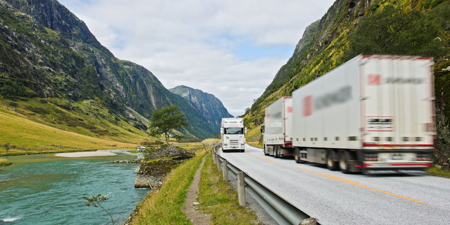 Lastebiler på norske veier omkranset av fjell.