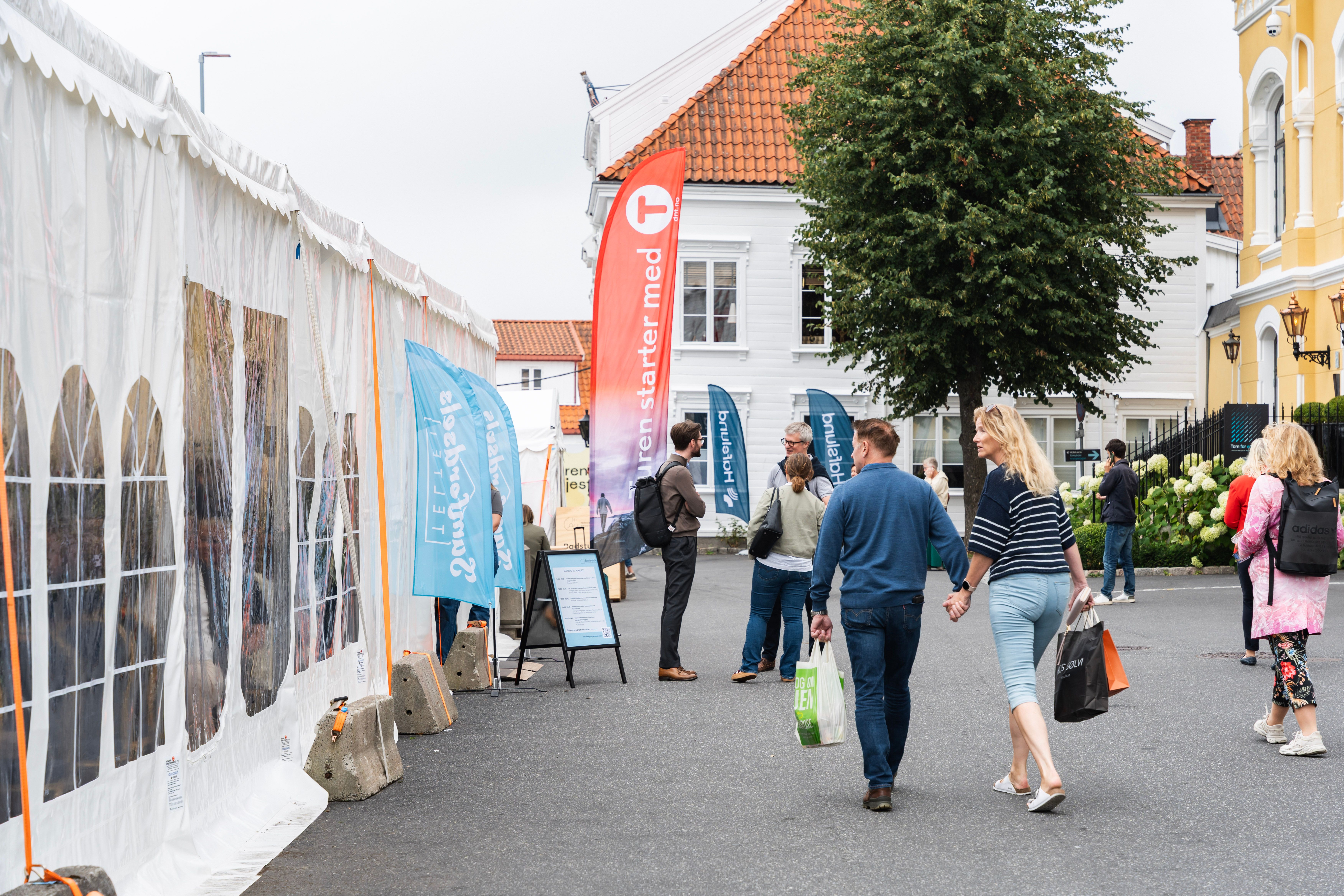 Besøkende går forbi Samferdselsteltet i Rådhusgaten i Arendal under Arendalsuka.